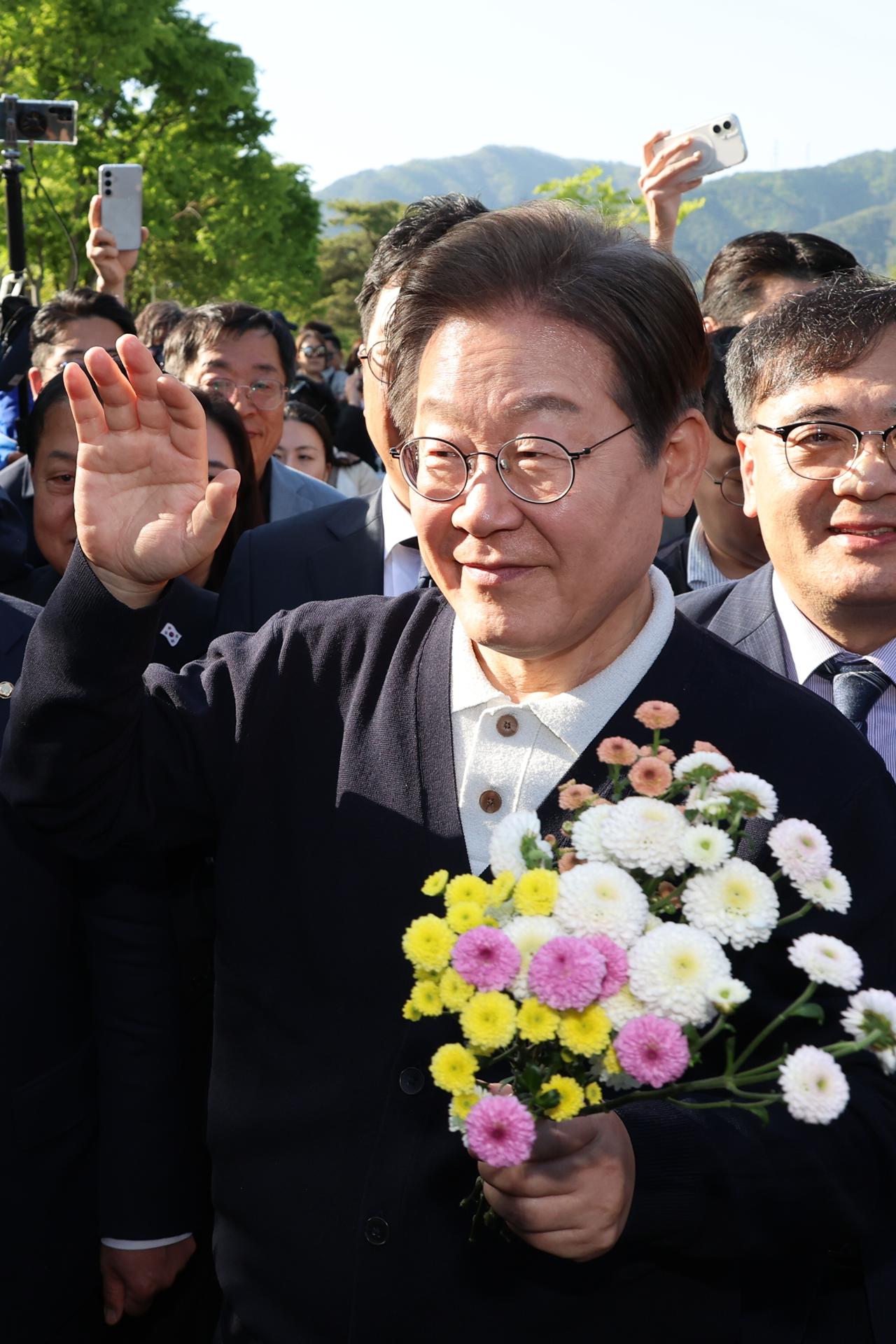Lee Jae-myung, candidato presidencial del Partido Demócrata liberal, saluda con un ramo de flores entregado por un simpatizante durante su visita al embalse de Uirimji en Jecheon, Corea del Sur, el 7 de mayo de 2025, mientras recorre el país en campaña electoral de cara a las elecciones presidenciales del 3 de junio. EFE/EPA/YONHAP SOUTH KOREA OUT