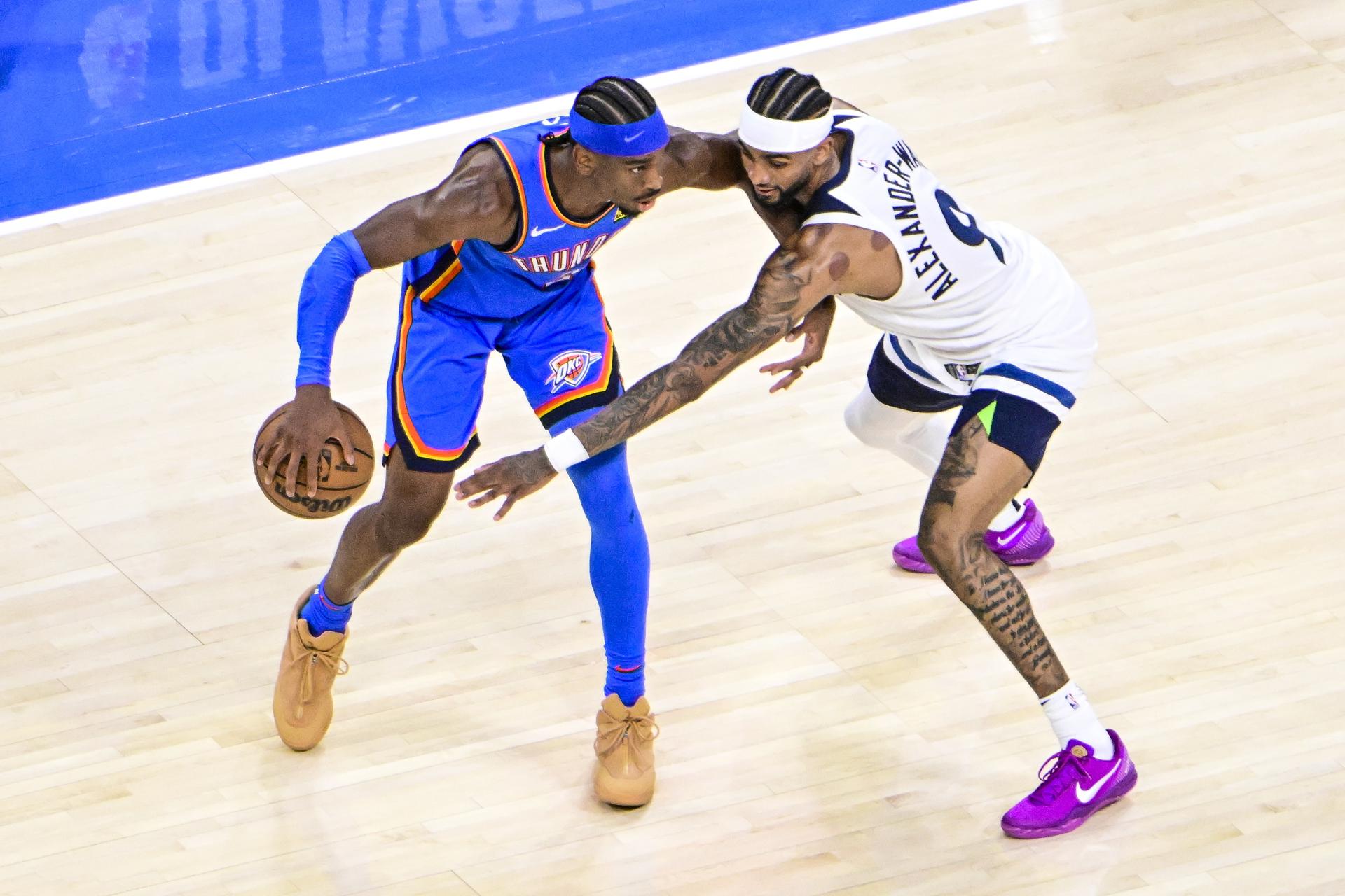 El escolta de los Thunder, Shai Gilgeous-Alexander (izquierda), avanza sobre el escolta de los Minnesota Timberwolves, Nickeil Alexander-Walker, durante el partido que ganaron los de Oklahoma por 118-103 y con el que han ampliado la ventaja a 2-0 en las finales del Oeste. EFE/EPA/GERALD LEONG