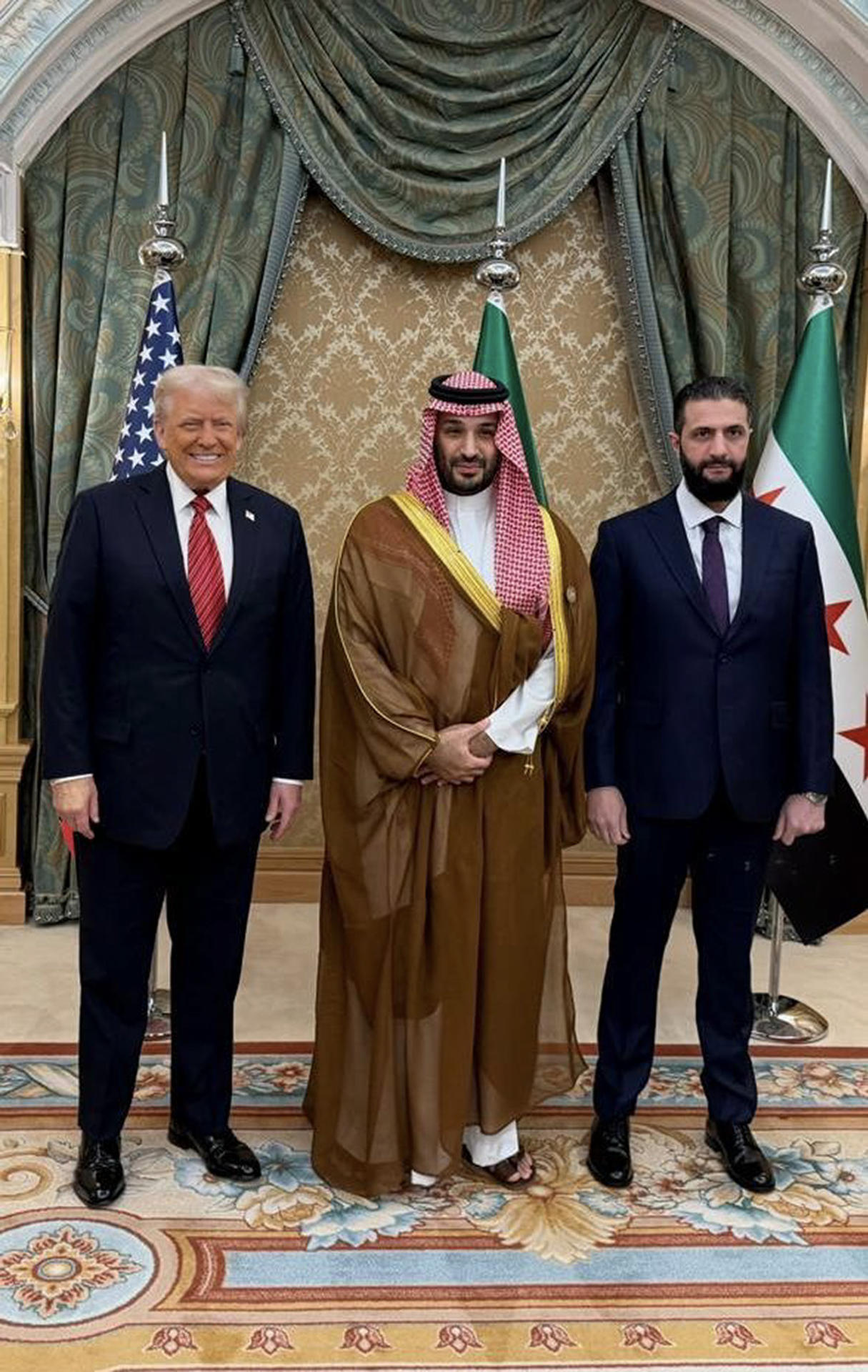 El presidente de Estados Unidos, Donald Trump (c), se reunió este miércoles con el presidente interino de Siria, Ahmed al Sharaa (i), durante más de media hora después de que el martes anunciara el levantamiento de todas las sanciones al nuevo gobierno de Damasco para darles "una oportunidad para ser grandes". La Casa Blanca detalló que en la reunión estuvo presente el príncipe heredero y de facto líder saudí, Mohamed bin Salmán (d), y se sumó por teléfono el presidente turco, Recep Tayyip Erdogan, quien "felicitó al presidente Trump por levantar las sanciones a Siria", algo que Bin Salmán definió como "valiente". EFE/Saudi Press Agency -SOLO USO EDITORIAL/SOLO DISPONIBLE PARA ILUSTRAR LA NOTICIA QUE ACOMPAÑA (CRÉDITO OBLIGATORIO)-