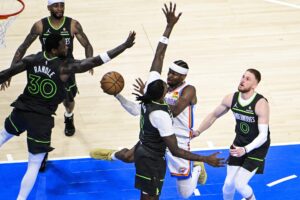 El base de los Oklahoma City Thunder, Shai Gilgeous-Alexander (2-R), tira a canasta contra el alero de los Minnesota Timberwolves, Julius Randle (I) y el pívot de los Minnesota Timberwolves, Naz Reid (C), durante la segunda parte del primer partido de las finales de la Conferencia Oeste entre los Minnesota Timberwolves y los Oklahoma City Thunder en el Paycom Center de Oklahoma City, Oklahoma, EE.UU. EFE/EPA/GERALD LEONG