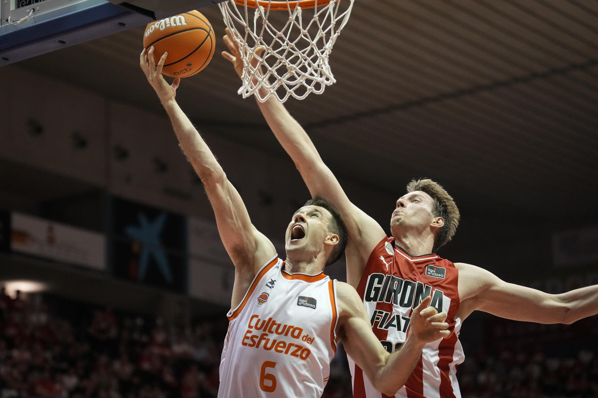 El alero del Valencia Basket Xabi López-Arostegui (i) entra a canasta defendido por Mindaugas Susinskas, del Básquet Girona, durante el partido de la Liga Endesa de baloncesto que se disputó en el pabellón de Fontajau de Girona. EFE/David Borrat.