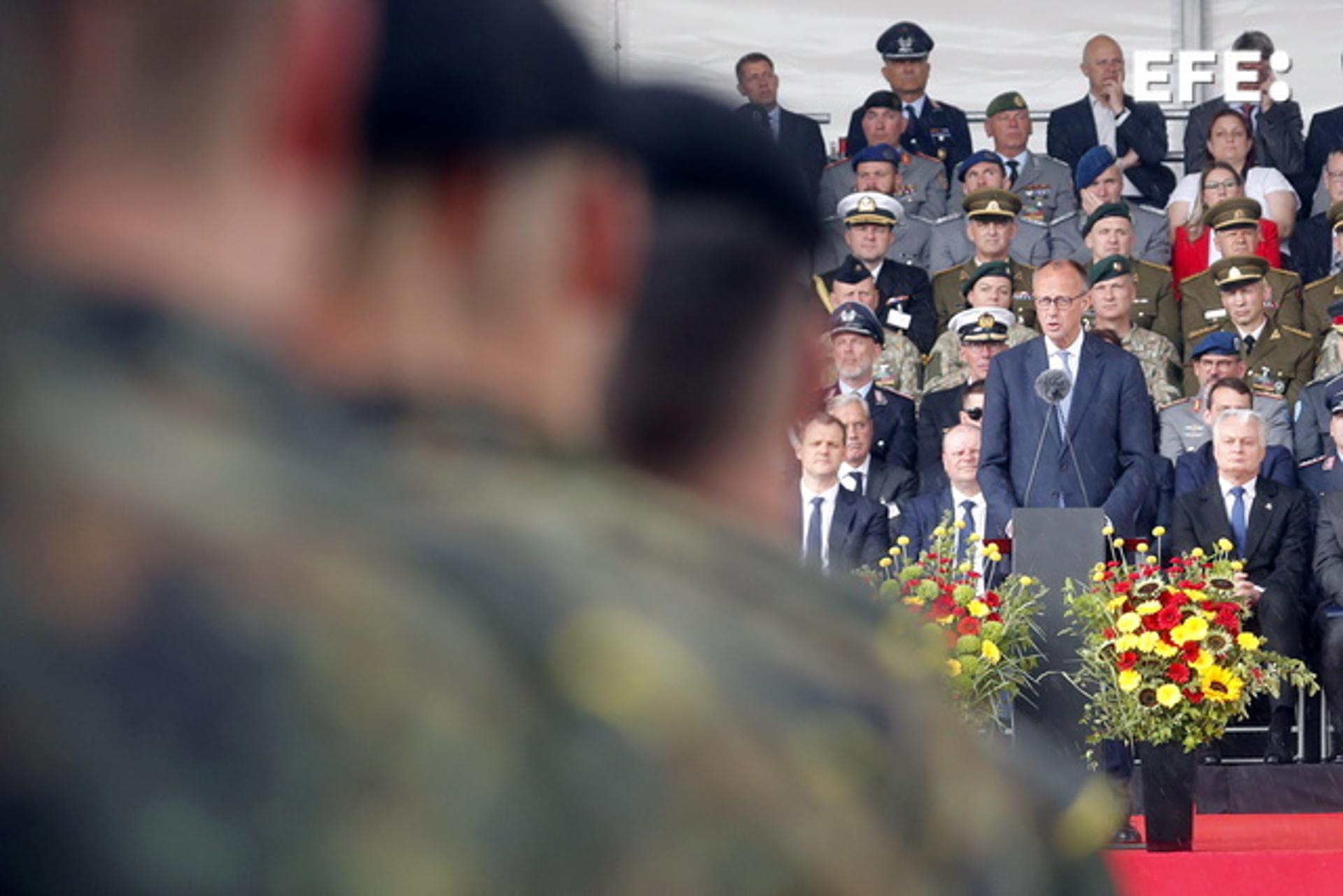El canciller alemán Friedrich Merz (2-R) pronuncia un discurso durante la inauguración de la 45ª Brigada Acorazada alemana 'Lituania', en la Plaza de la Catedral de Vilna, Lituania, el 22 de mayo de 2025. La Brigada en Lituania se activó el 01 de abril de 2025 y estará formada por unos 5.000 efectivos militares y civiles de la Bundeswehr, y se espera que alcance la plena capacidad operativa de combate en 2027. (Alemania, Lituania) EFE/EPA/TOMS KALNINS
