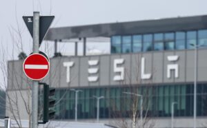 Fotografía de archivo que muestra una señal de transito frente a una sala de exposición de Tesla en Gruenheide (Alemania). EFE/ Hannibal Hanschke