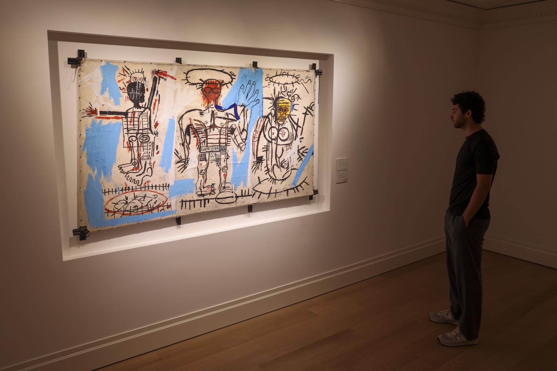 Una persona observa 'Baby Boom' de Jean-Michel Basquiat, expuesta en la casa de subastas Christie's en Nueva York, Estados Unidos. EFE/EPA/SARAH YENESEL