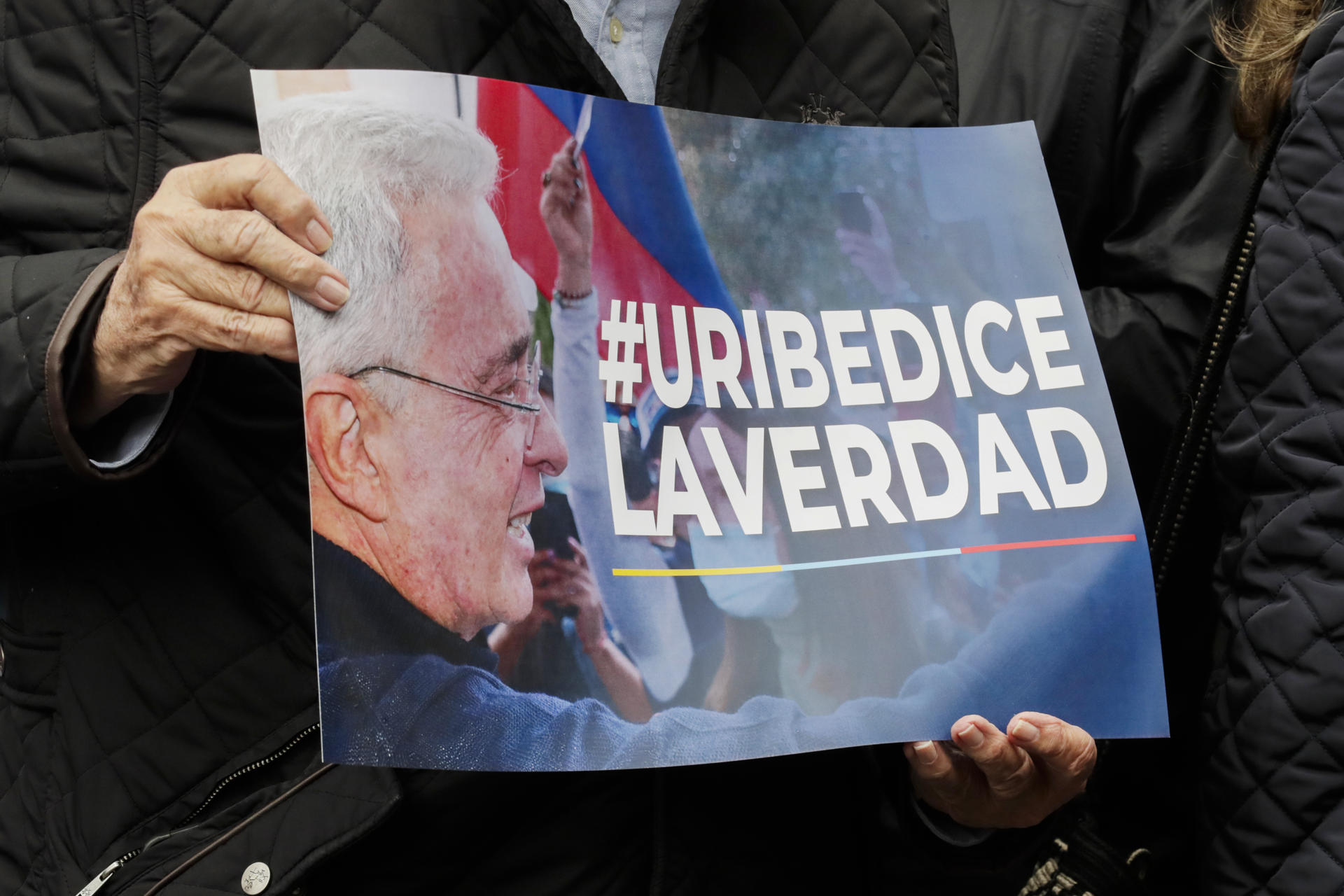 Una persona sostiene un cartel en apoyo al expresidente colombiano Álvaro Uribe este lunes, frente a los juzgados de Paloquemao en Bogotá (Colombia). EFE/Carlos Ortega