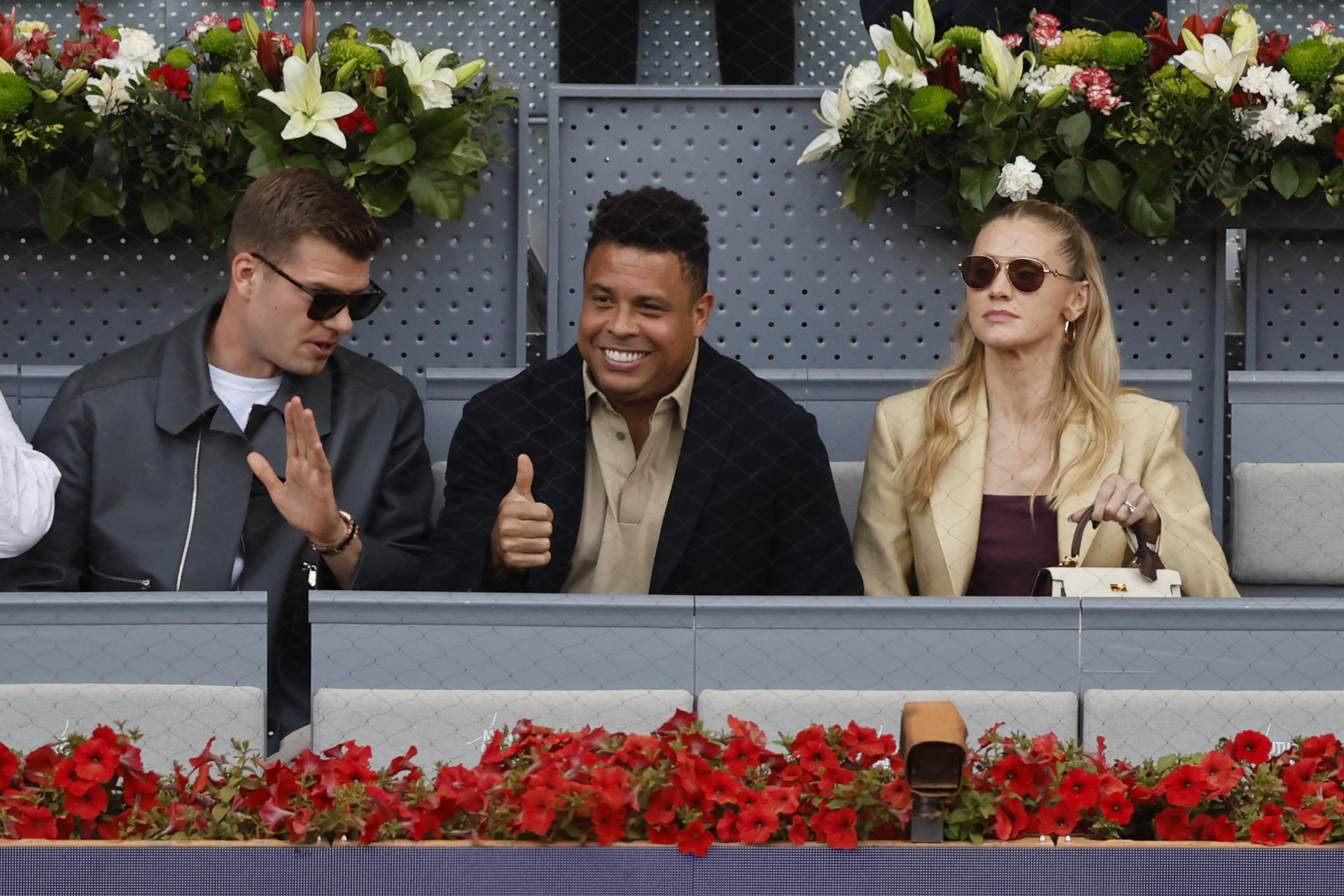 El exfutbolista y presidente del Real Valladolid, Ronaldo Nazario (c), su esposa Celina Locks (d) y el delantero del Atlético de Madrid Alexander Sorloth, antes de la final del Mutua Madrid Open de tenis que el noruego Casper Rudd y el británico Jack Draper disputan este domingo en la Caja Mágica, en Madrid. EFE/Sergio Pérez