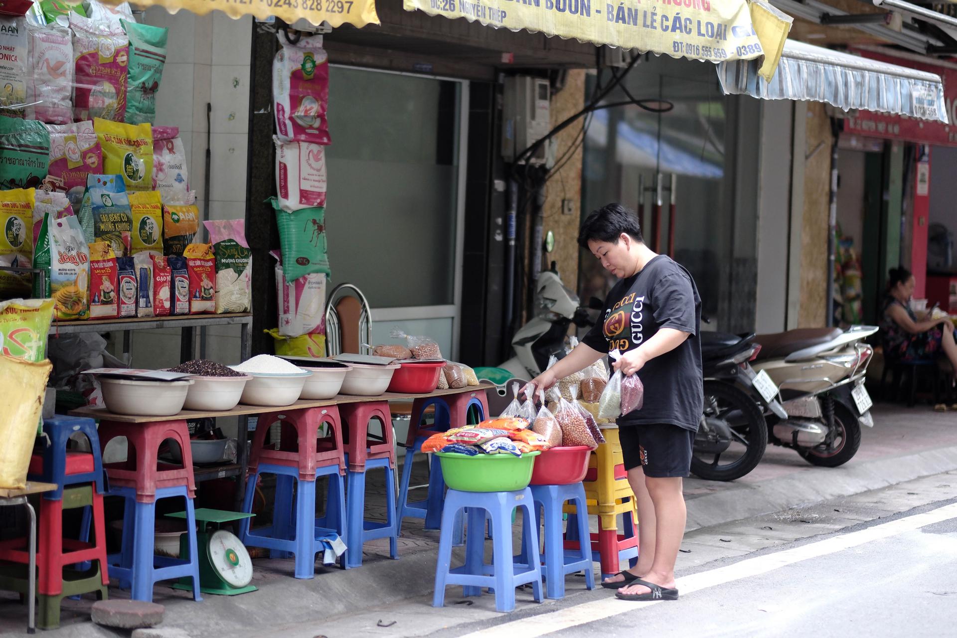 HANOI (Vietnam), 21/05/2025.- A woman selling rice and beans waits for costumers in a street in Hanoi, Vietnam, 21 May 2025. Vietnam will export the first batch of low-emission rice to the Japanese market this May, according to Pham Thai Binh, Chairman of Board of Directors of Trung An High-Tech Agriculture Joint Stock Company. (Japón) EFE/EPA/LUONG THAI LINH