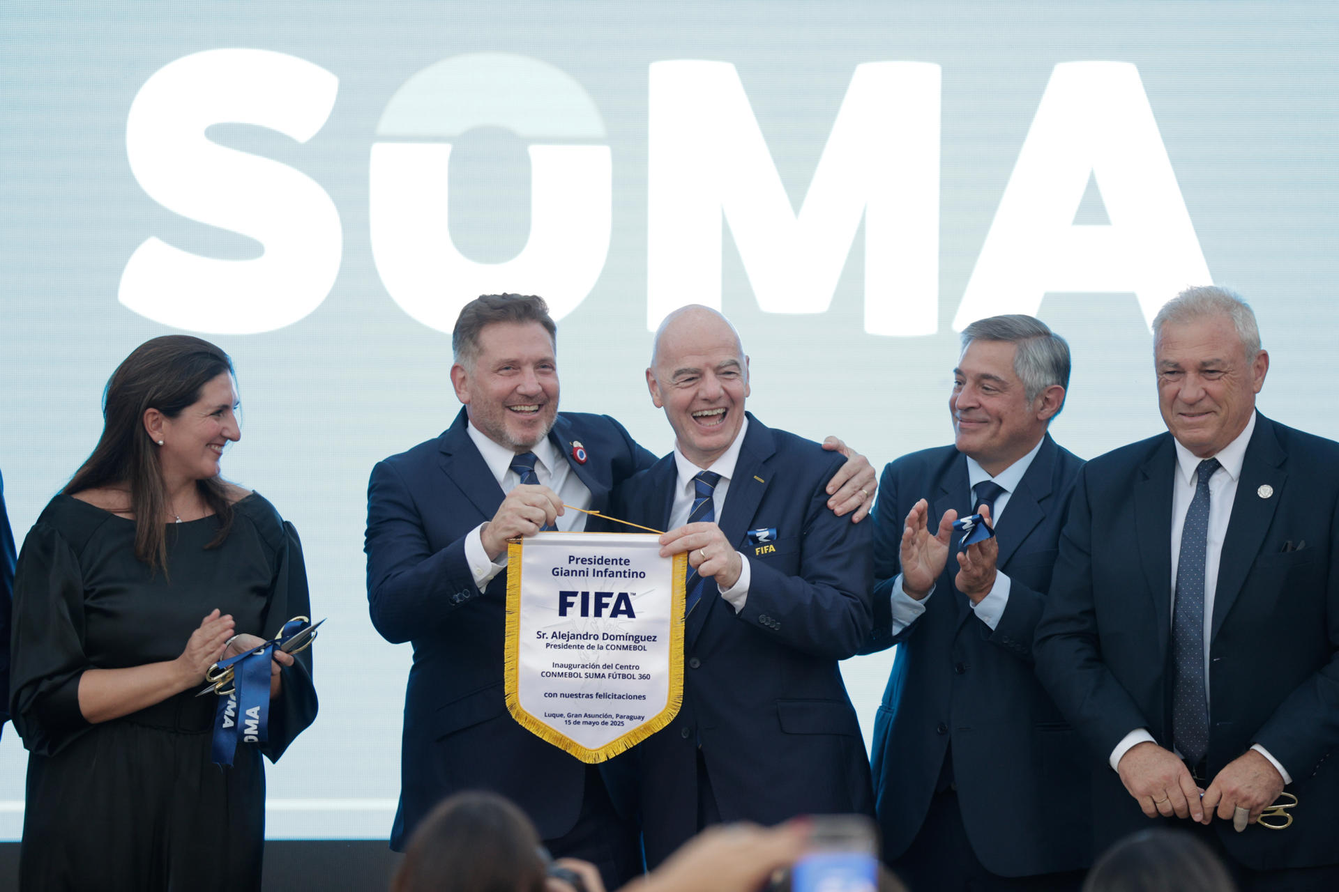 El presidente de la Confederación Sudamericana de Fútbol (Conmebol), Alejandro Domínguez (ci), recibe un obsequio del presidente de la FIFA, Gianni Infantino (cd), durante un acto de inauguración del complejo ‘Suma’ de la Conmebol, en Luque (Paraguay). EFE/ Juan Pablo Pino