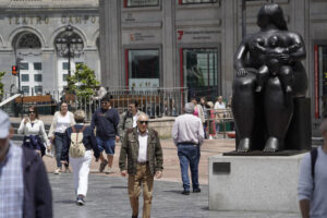 Paseantes por la plaza de la Escandalera con el Teatro Campoamor al fondo este viernes. EFE/Paco Paredes