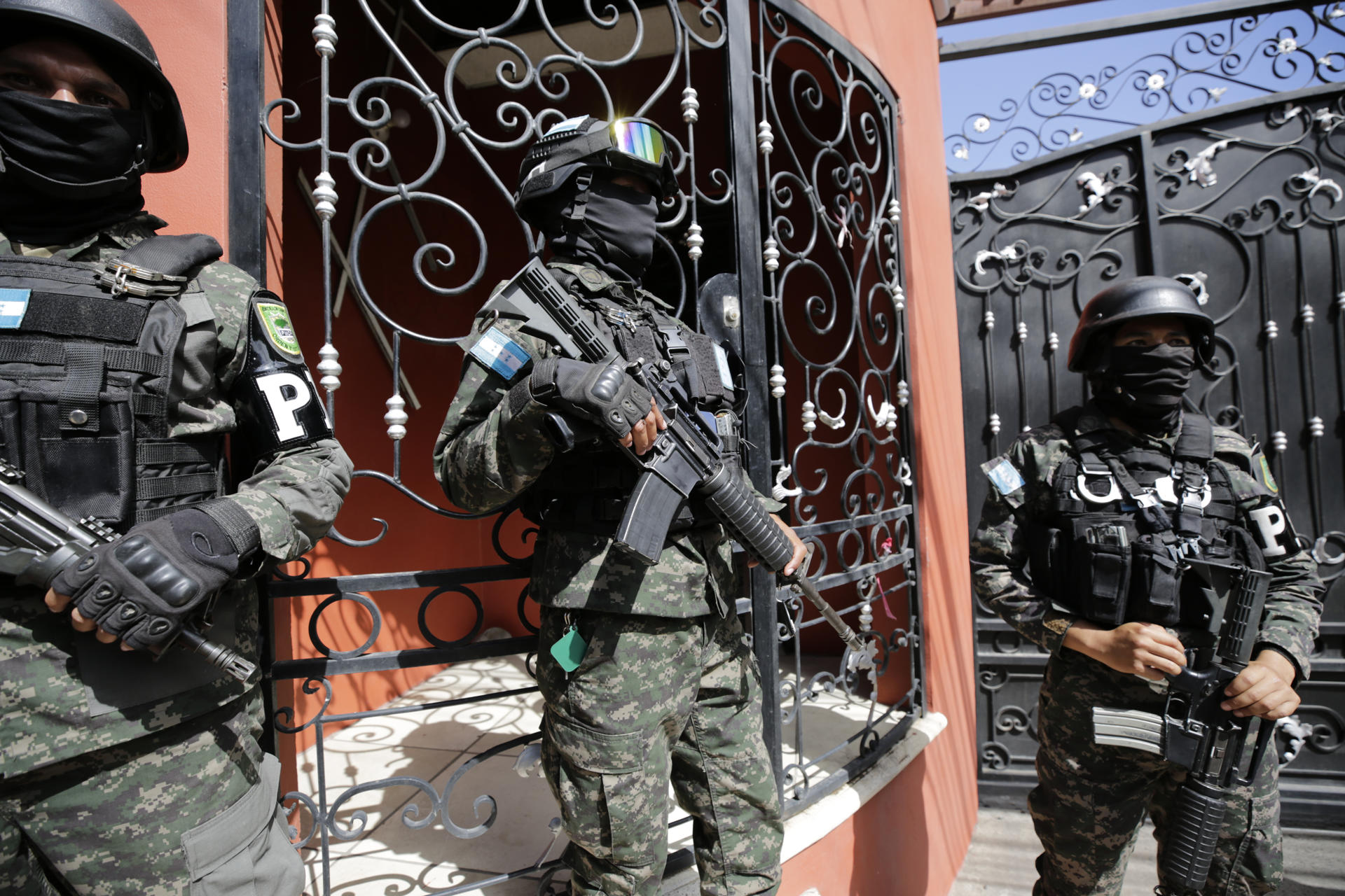 Militares hondureños acompañan a un agente de la Dirección de Lucha Contra el Narcotráfico (DLCN) en el allanamiento de la residencia del exjefe del Estado Mayor Conjunto de las Fuerzas Armadas de Honduras Romero Vásquez este sábado, en Tegucigalpa (Honduras). EFE/ Gustavo Amador