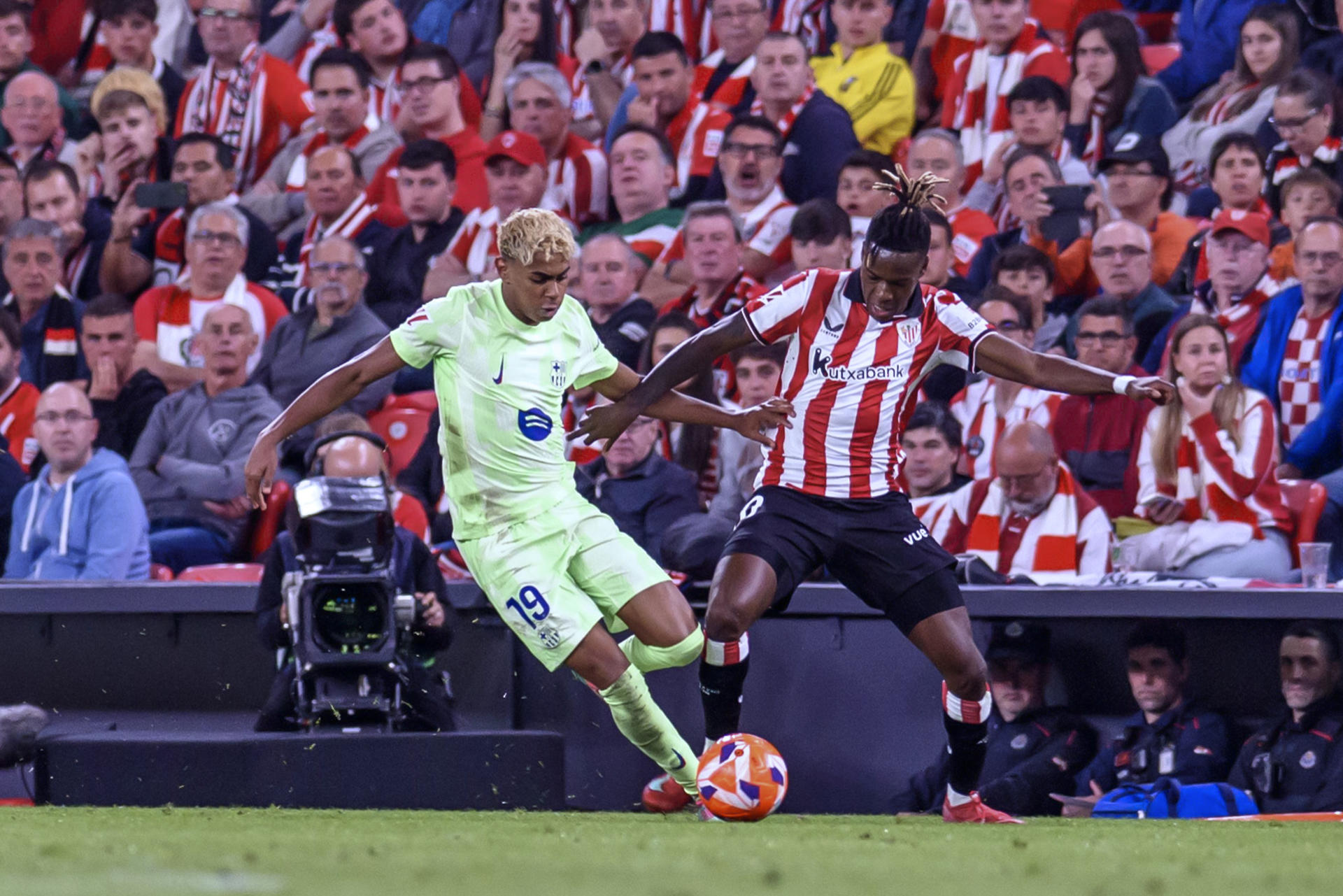 El delantero del Athletic Nico Williams (d) pelea un balón con Lamine Yamal, del Barcelona, durante el partido de la última jornada de LaLiga de fútbol disputado en San Mamés. EFE/Javier Zorrilla