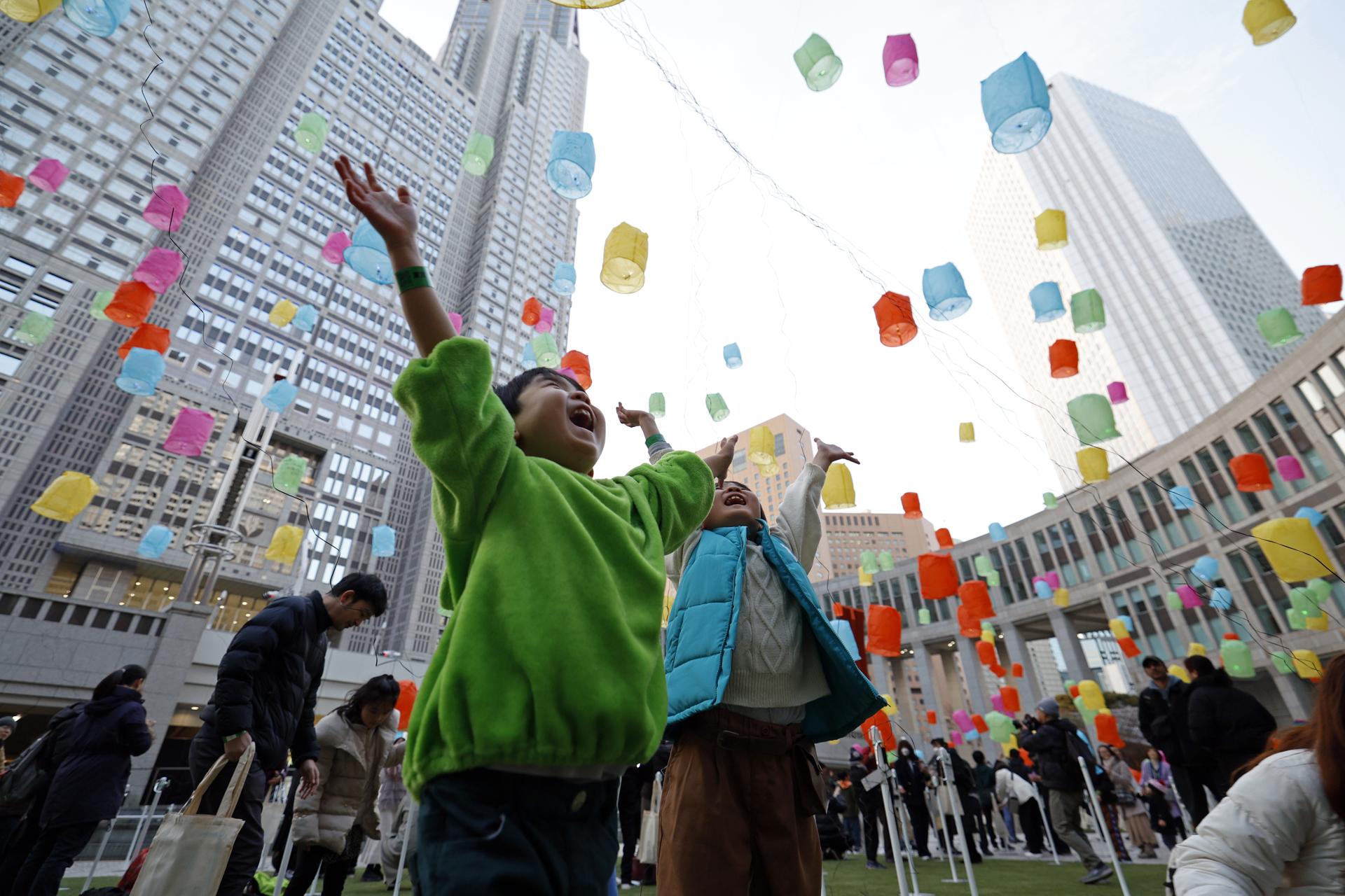 Niños japoneses contemplan linternas de papel mientras se elevan al cielo, en Tokio, en una imagen de archivo. EFE/EPA/FRANCK ROBICHON