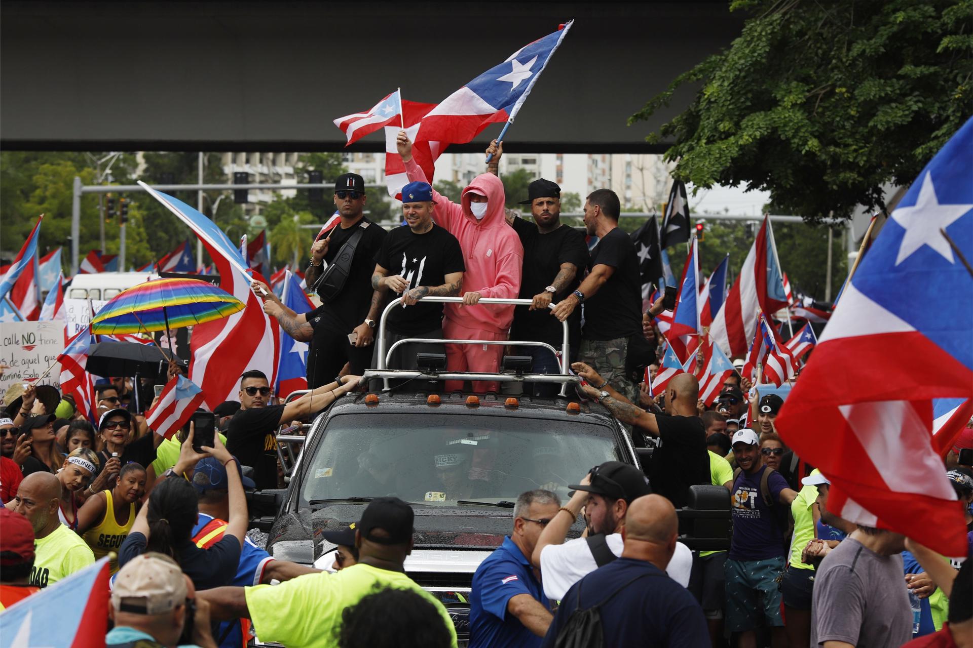 Fotografía de archivo en la que aparecen (de i a d) los cantantes Wisin, Residente, Bad Bunny y Nicky Jam, sobre un camión, durante una marcha en San Juan (Puerto Rico). EFE/Thais Llorca