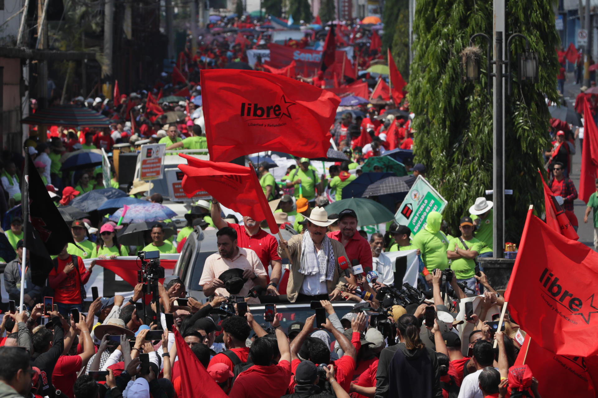 El expresidente de Honduras Manuel Zelaya (c-d) fue captado este jueves, 1 de mayo, al encabezar la marcha del Día Internacional del Trabajo, en Tegucigalpa (Honduras). EFE/Gustavo Amador