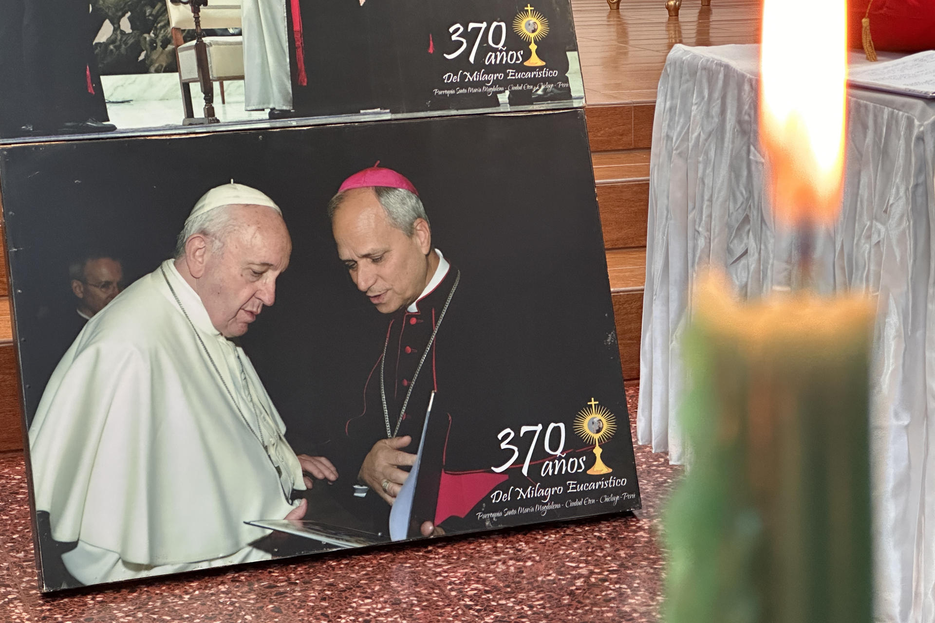 Fotografía que muestra una imagen de un encuentro del entonces obispo Robert Prevost entregando al papa Francisco un libro con testimonios de fe hechos por visitantes a la parroquia Santa María Magdalena que describen milagros realizados por el Divino Niño del Milagro, este viernes en Eten, provincia de Chiclayo (Perú). EFE/ Mikhail Huacan