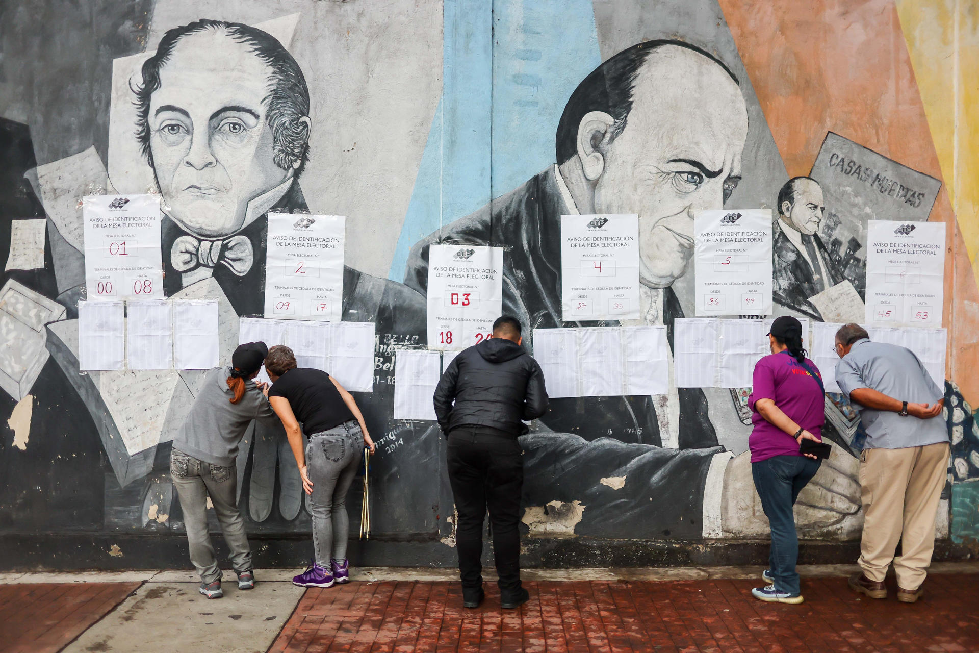 Personas ubican su mesa electoral en un centro de votación este domingo, en Caracas (Venezuela). EFE/ Miguel Gutiérrez