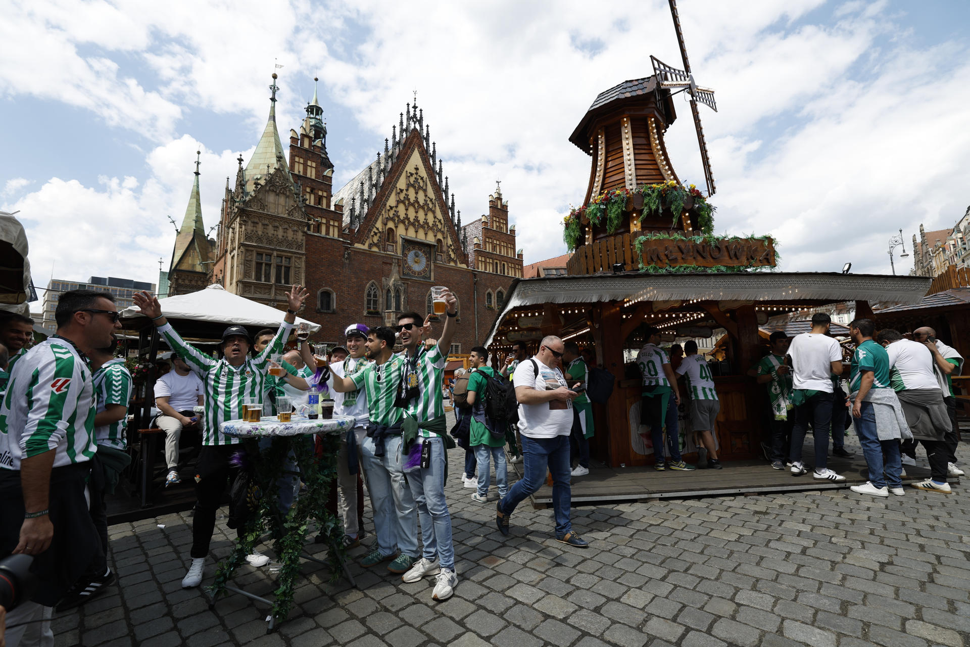 Aficionados del Betis en la Plaza Solny de Breslavia (Polonia) cantan y beben un día antes de la final de la Liga Conferencia, en la que el equipo verdiblanco tiene una cita con la historia y se enfrenta ante uno de los grandes del fútbol europeo, el Chelsea inglés. EFE/Julio Muñoz