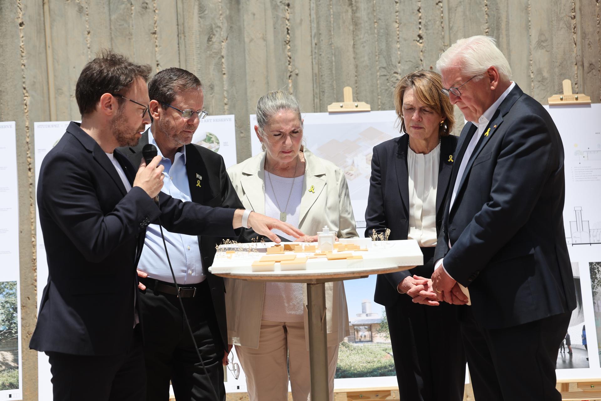 El presidente israelí Isaac Herzog (2-I), su esposa Michal Herzog (3-I), el presidente alemán Frank-Walter Steinmeier (D) y su esposa Elke Buedenbender (2-D) llegan para dar declaraciones a los medios en el lugar donde solía estar la antigua Galería de Arte Be'eri durante su visita al Kibutz Be'eri, cerca de la frontera con Gaza, en el sur de Israel, el 14 de mayo de 2025. Los dos presidentes asisten a una ceremonia de colocación de la primera piedra en la antigua galería de arte Be'eri, que fue arruinada durante el ataque de Hamás del 7 de octubre, y obtienen una visión general de la nueva galería que se construirá en el futuro en el Kibutz Be'eri. La visita de Steinmeier tiene lugar con motivo del 60º aniversario del establecimiento de relaciones diplomáticas entre Alemania e Israel. (Alemania, Kibutz) EFE/EPA/ABIR SULTAN