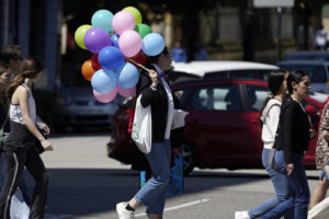 Imagen de una chica con globos en una céntrica calle de Oviedo en una soleada mañana, este sábado. EFE/Paco Paredes