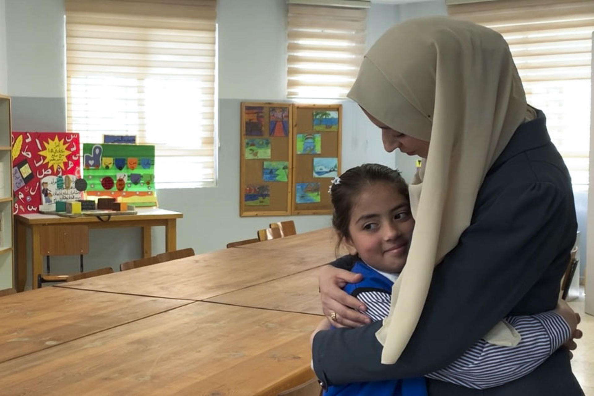 - Anuar (d), una joven madre de 27 años, junto a su hija de 8, Tagrid, en una escuela de la UNRWA (la agencia de la ONU para los refugiados palestinos) en el campamento de Shuafat. A pocos días de que se cumpla el plazo dado por las autoridades israelíes para clausurar las escuelas de la UNRWA en Jerusalén Este, las madres del campamento de Shuafat se niegan a contemplar alternativas. "Creo que esta escuela es extraordinaria, es excepcional. Yo estudié en esta escuela y por eso traje a mi hija aquí", explica a EFE Anuar. EFE/ Jorge Dastis