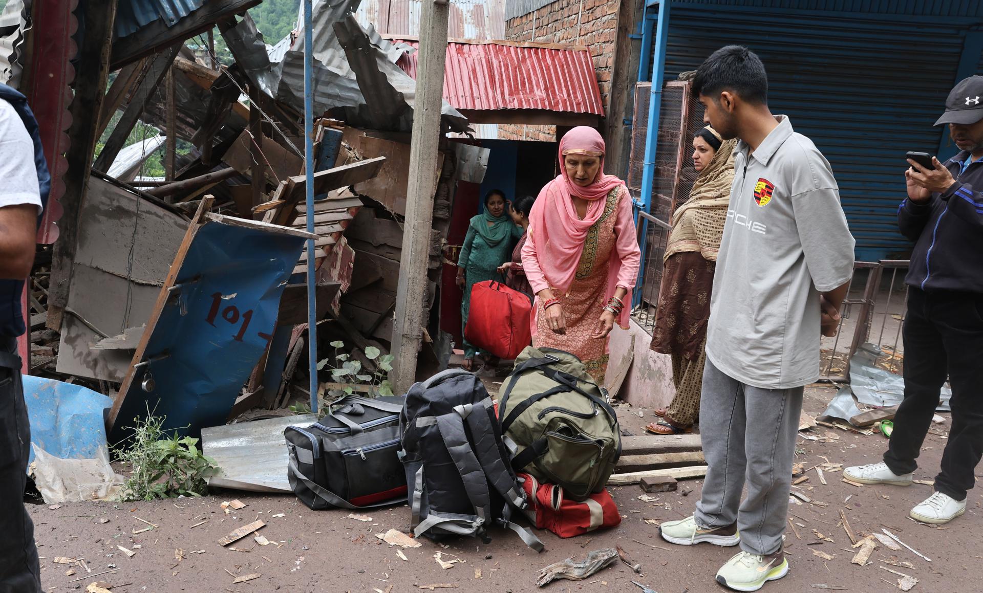 Una mujer cachemir india recoge este viernes, 9 de mayo, sus pertenencias e inspecciona una casa dañada por los bombardeos transfronterizos de Pakistán, cerca de la línea de control en Lagamma Uri. EFE/Farooq Khan