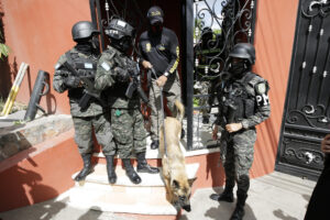 Militares hondureños acompañan a un agente de la Dirección de Lucha Contra el Narcotráfico (DLCN) en el allanamiento de la residencia del exjefe del Estado Mayor Conjunto de las Fuerzas Armadas de Honduras Romero Vásquez este sábado, en Tegucigalpa (Honduras). EFE/ Gustavo Amador