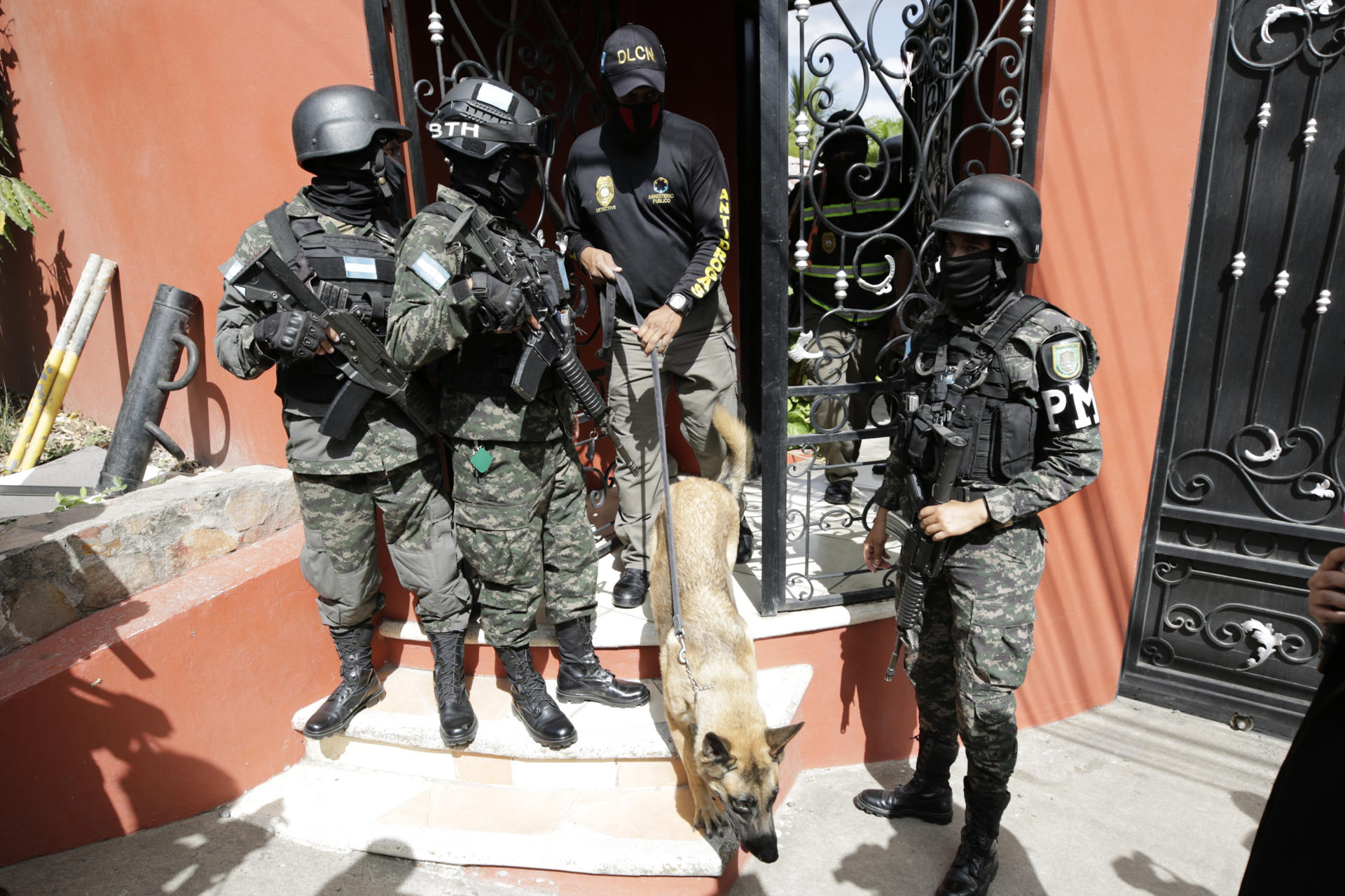 Militares hondureños acompañan a un agente de la Dirección de Lucha Contra el Narcotráfico (DLCN) en el allanamiento de la residencia del exjefe del Estado Mayor Conjunto de las Fuerzas Armadas de Honduras Romero Vásquez este sábado, en Tegucigalpa (Honduras). EFE/ Gustavo Amador