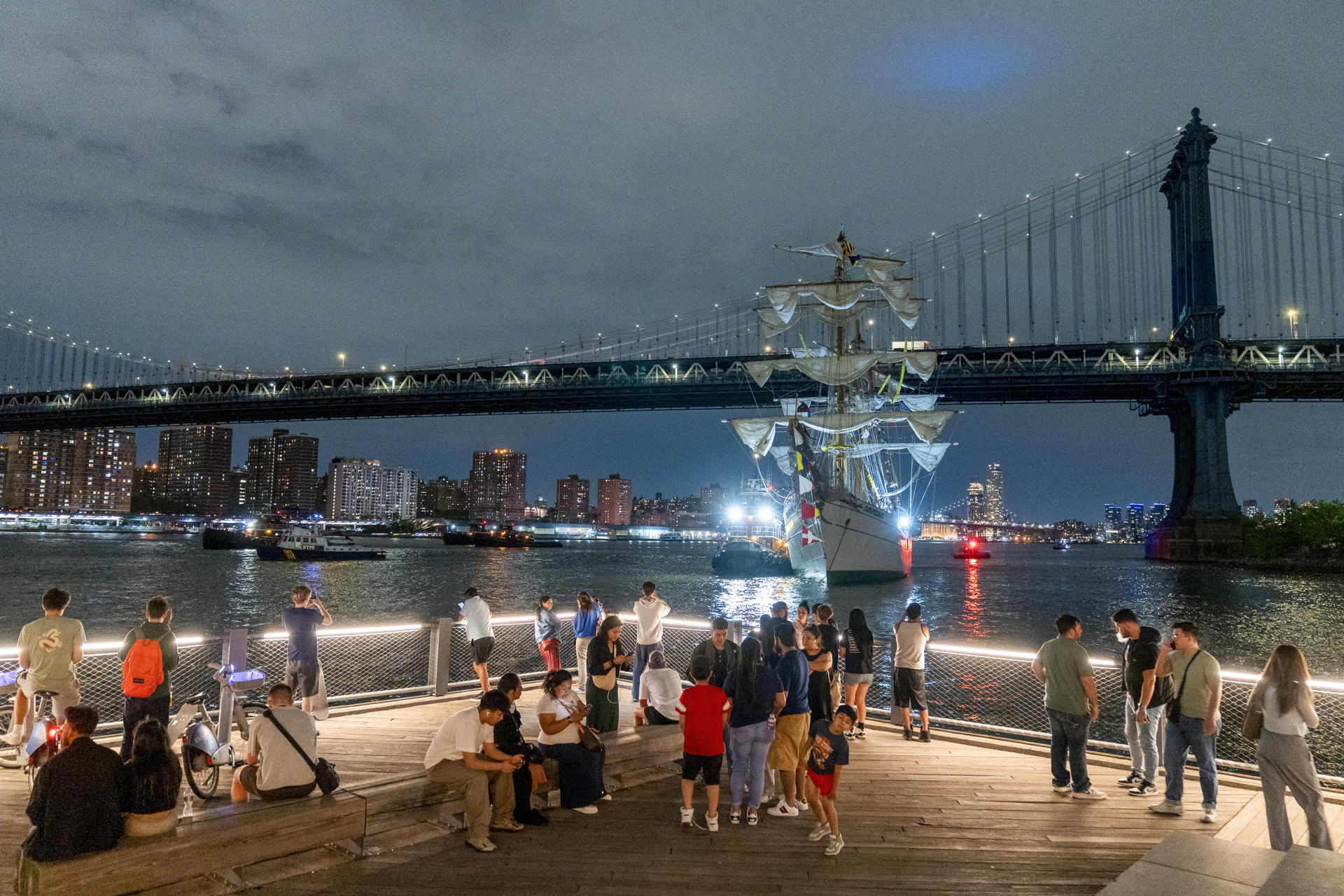 Personas observan el buque escuela mexicano Cuauhtémoc junto al puente de Brooklyn este sábado, en Nueva York (EE.UU.). EFE/ Angel Colmenares