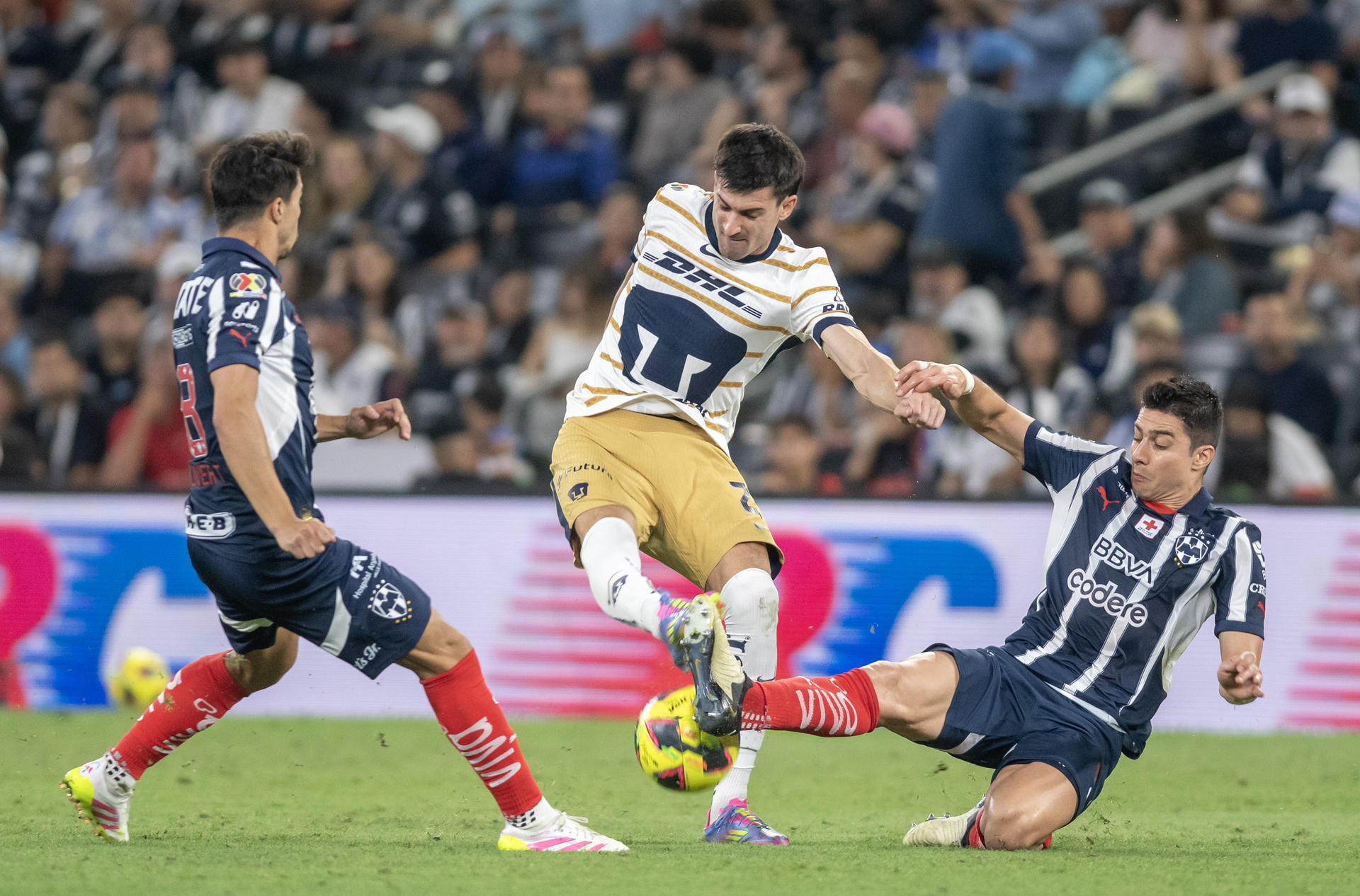 Stefan Medina (d) y Oliver Torres (i), de Monterrey, disputan el balón con Ignacio Pussetto (c), de Pumas, en el partido correspondiente al Play In 2 del Torneo Clausura 2025 de México. EFE/Miguel Sierra