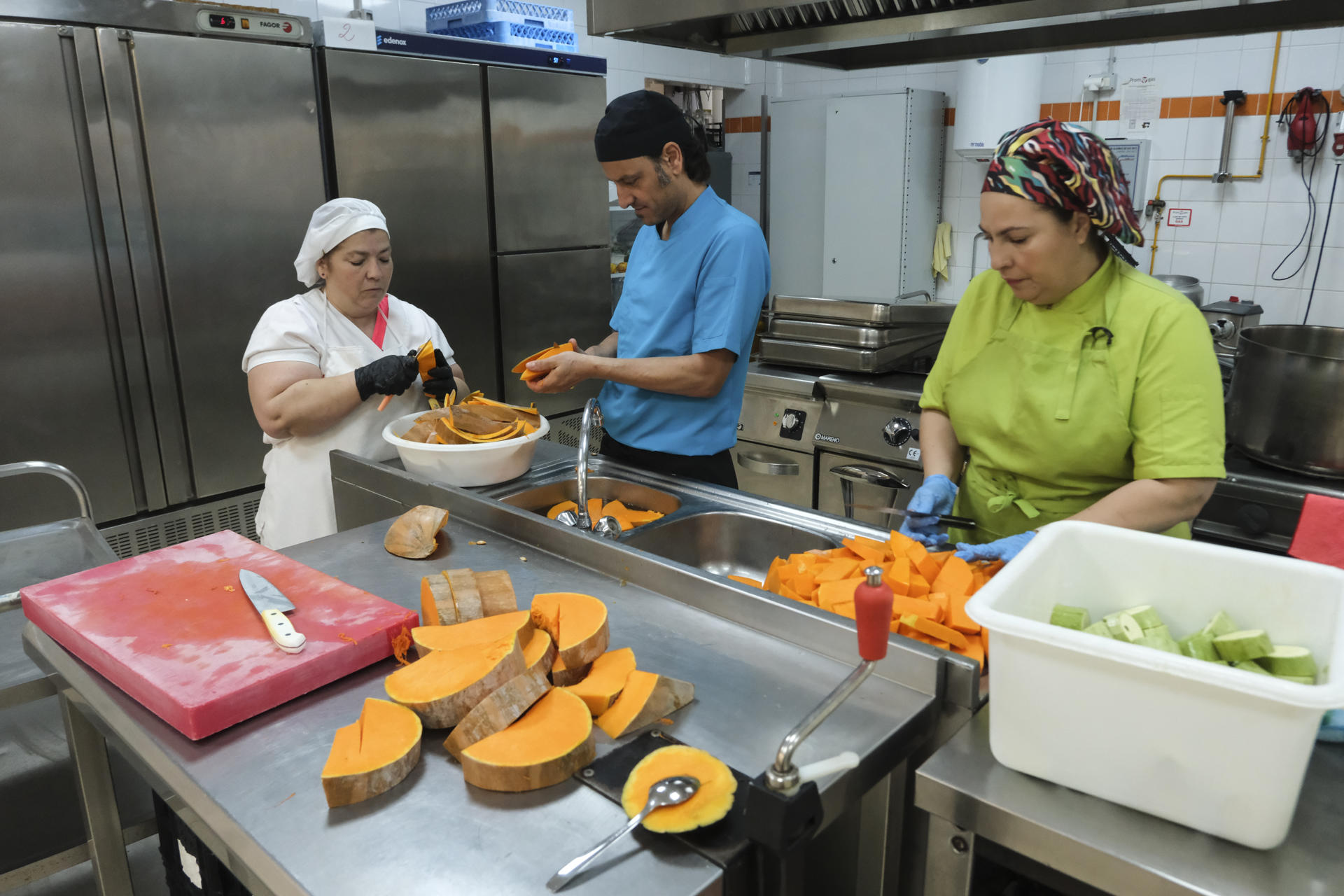 Los agricultores, los educadores, los cocineros, los alumnos y las familias lo tienen claro: el programa que lleva frutas y verduras ecológicas y de temporada desde las huertas hasta los centros educativos de Canarias es todo un éxito. Se llama Ecocomedores e inspira el decreto que el Consejo de Ministros ha aprobado para el resto de España. En la imagen, trabajadores de la cocina del colegio Las Mercedes, en La Laguna (Tenerife) preparan el almuerzo para los alumnos. EFE/Alberto Valdés