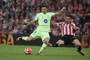 El delantero del Barcelona Robert Lewandowski (i) se dispone a chutar ante Yuri Berchiche, del Athletic, durante el partido de la última jornada de LaLiga de fútbol que Athletic Club y FC Barcelona disputaron en el estadio de San Mamés. EFE/Luis Tejido
