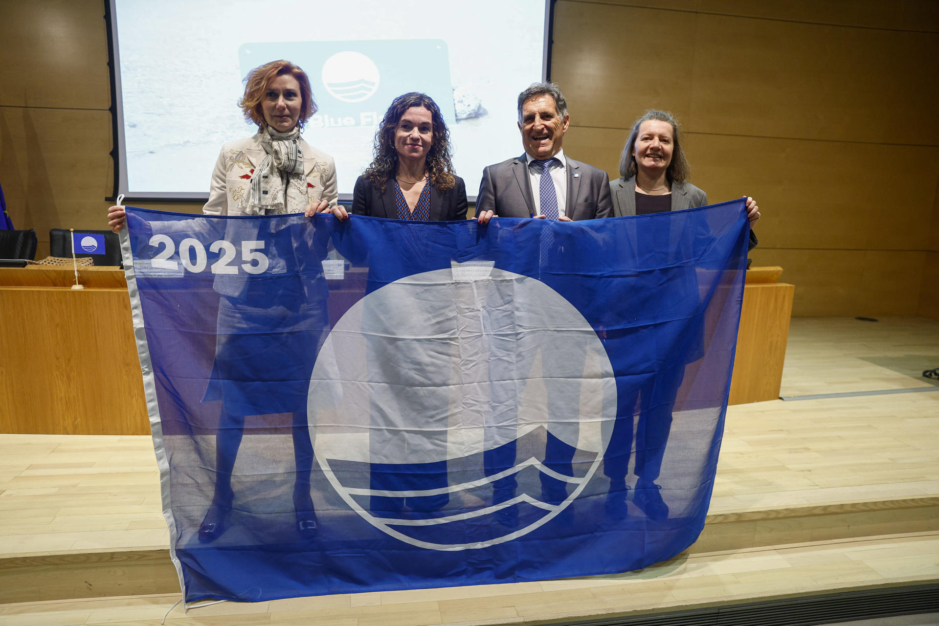 La secretaria de Estado de Turismo Rosario Sánchez Grau (2i), la asesora del Secretario General para Sosteniblidad ONU Turismo Isabel Oliver Sagreras (i) y el presidente de ADEAC José Palacios Aguilar, durante el acto de la Asociación de Educación Ambiental y del Consumidor (Adeac) este martes en Madrid, que da a conocer la lista de playas, puertos y embarcaciones turísticas galardonadas con Bandera Azul 2025. EFE/ Rodrigo Jiménez