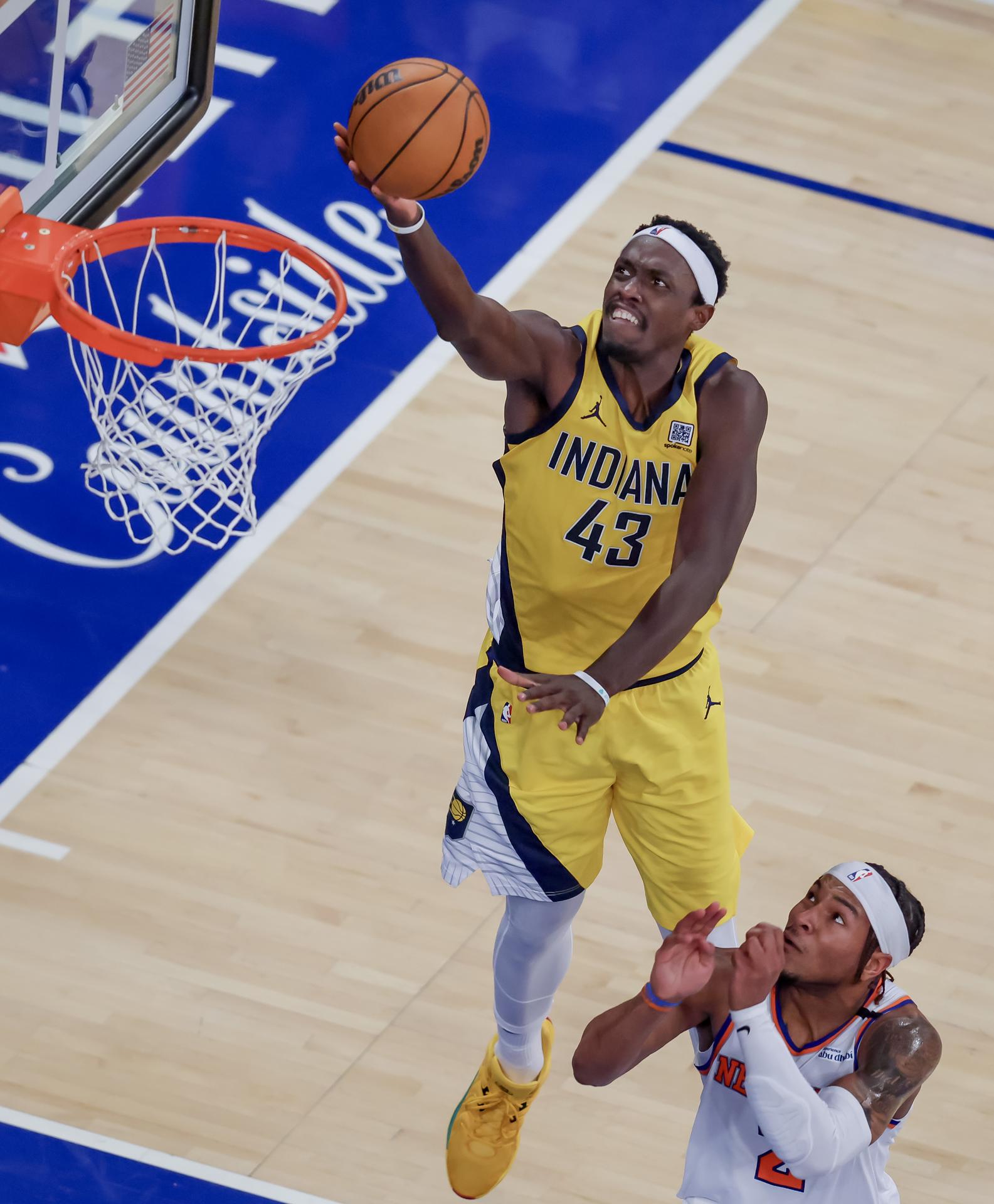 Pascal Siakam (i) de los Indiana Pacers se eleva a la cesta ante la mirada de Miles McBride de los New York Knicks. EFE/JUSTIN LANE