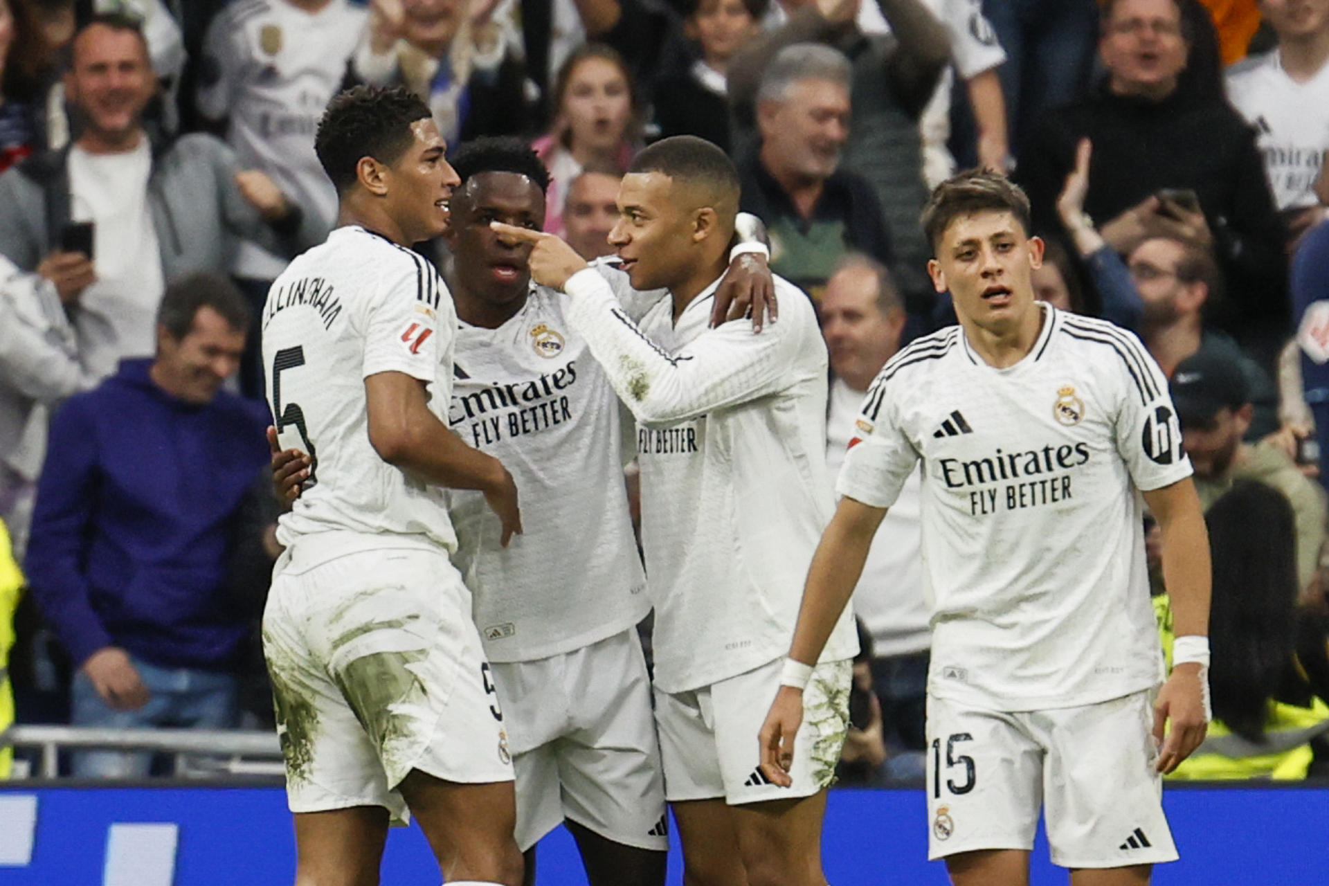 El delantero del Real Madrid Kylian Mbappé (2d) celebra con sus compañeros Jude Bellingham (i), Vini Jr. (2i) y Arda Güler (d) después de marcar el 2-0 en el partido entre el Real Madrid y el Celta de Vigo este domingo en el estadio Santiago Bernabéu en Madrid este domingo. EFE/ Blanca Míllez