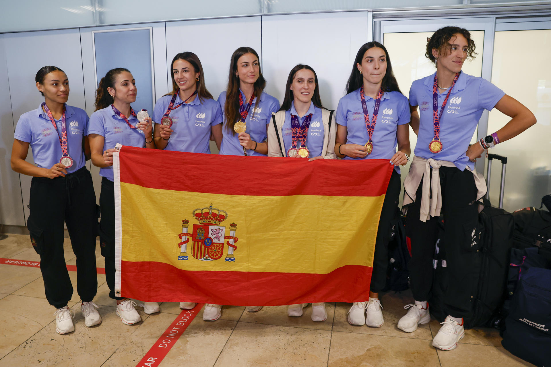 Las componentes de los equipos españoles de relevos femenino 4x400m y 4x100m posan con las medallas de oro y plata, respectivamente, ganadas en el Mundial de relevos de Guanzhou (China) a su llegada al Aeropuerto Internacional Adolfo Suárez Madrid-Barajas. (De izq a der) Jaël Betsué, Maribel Pérez, Esperança Cladera, Blanca Hervás, Paula Sevilla, Eva Santidrián y Daniela Fra.EFE/ Javier Lizón