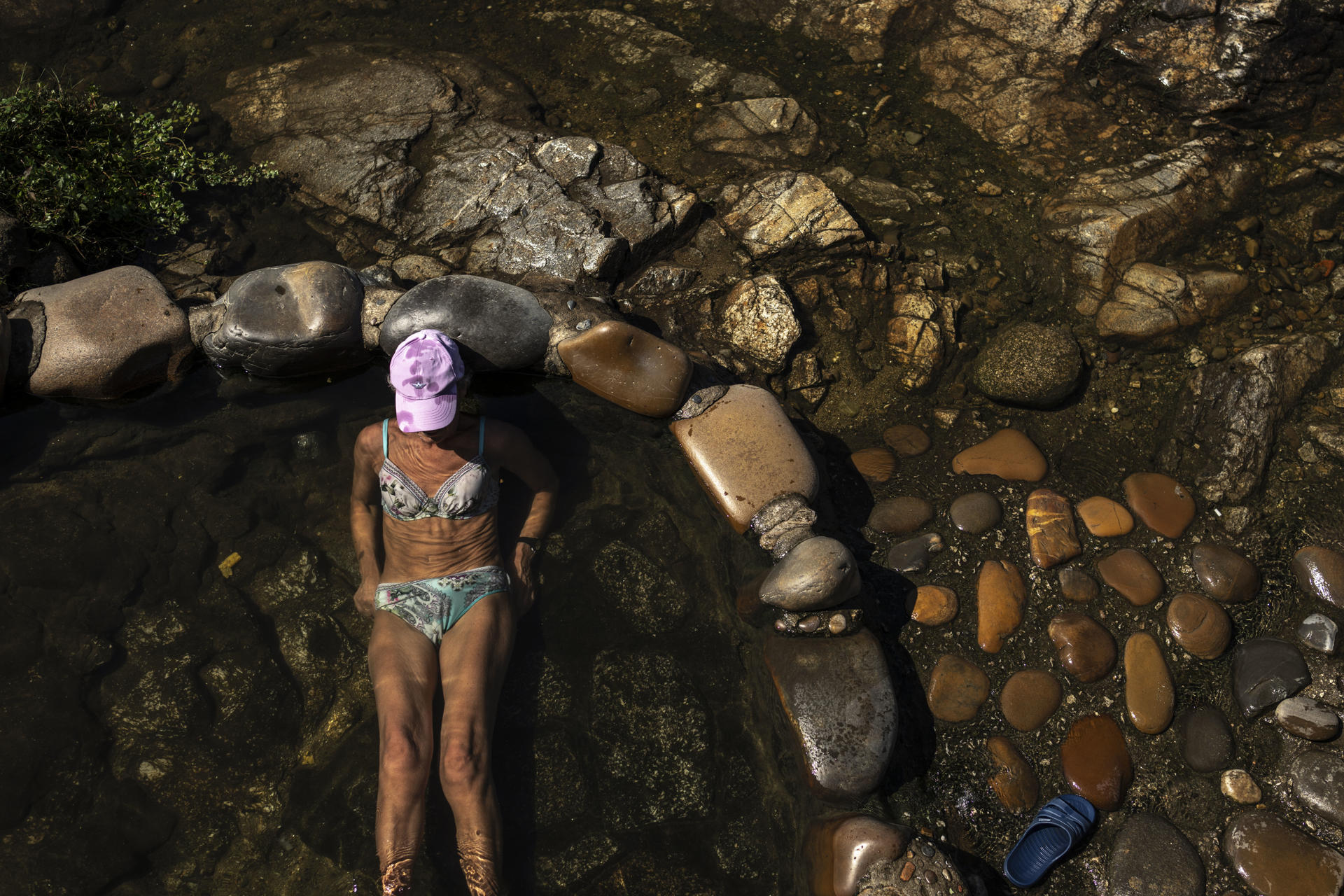 Una mujer se refresca en la zona fluvial del río Miño y las termas de A Chavasqueira, este jueves en Ourense (Galicia). EFE /Brais Lorenzo