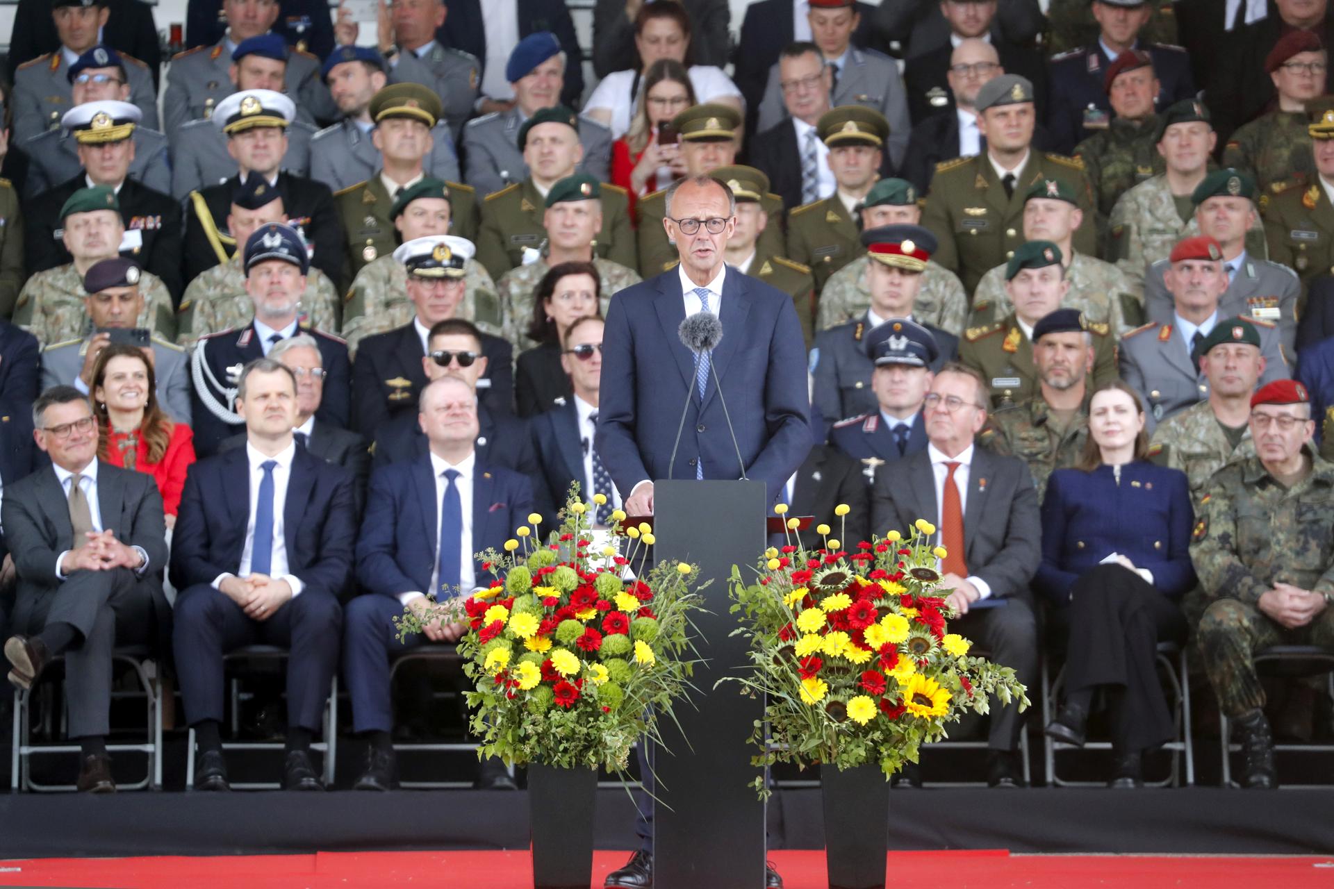 El canciller alemán Friedrich Merz (C) pronuncia un discurso durante la inauguración de la 45ª Brigada Blindada Alemana 'Lituania', en la Plaza de la Catedral de Vilna, Lituania, el 22 de mayo de 2025. La Brigada en Lituania se activó el 01 de abril de 2025 y estará formada por unos 5.000 militares y civiles de la Bundeswehr, y se espera que alcance una capacidad de combate operativa total en 2027. (Alemania, Lituania) EFE/EPA/TOMS KALNINS