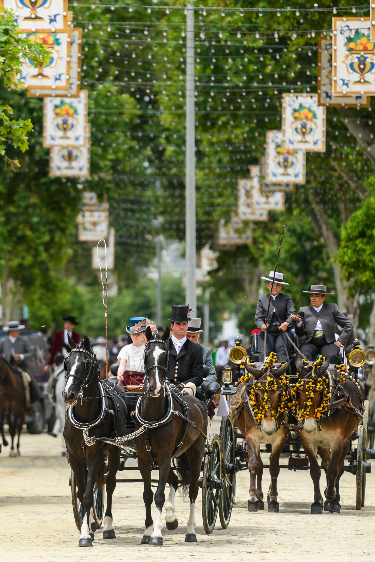 Coches de caballos pasean por una de las calles de la Feria de Abril de Sevilla, este miércoles. EFE/ Raúl Caro.