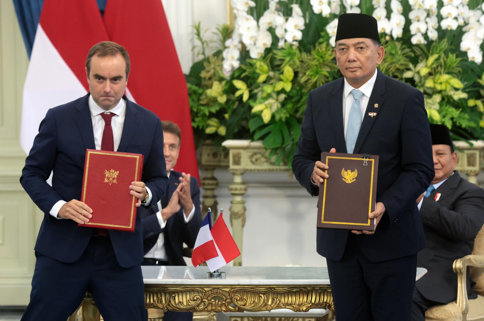 JAKARTA (Indonesia), 28/05/2025.- French Minister of the Armed Forces Sebastien Lecornu (L) and Indonesian Defense Minister Sjafrie Sjamsoeddin (R) hold copies of a Memorandum of Understanding during a signing ceremony witnessed by France's President Emmanuel Macron (L, back) and Indonesian President Prabowo Subianto (R, back) at the Presidential Palace in Jakarta, Indonesia, 28 May 2025. Macron continues his Southeast Asian tour with a state visit to Indonesia from 27 to 29 May 2025. (Francia) EFE/EPA/ADI WEDA