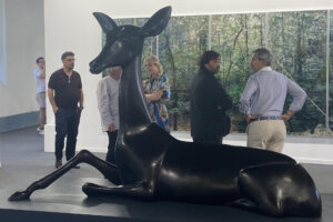 Varias personas conversan alrededor del ciervo negro de grandes dimensiones que preside la muestra de la galería luso-española Pedro Cera, uno de los 29 espacios españoles que desde el jueves y hasta el domingo se pueden visitar en la octava edición de la feria de arte contemporáneo ARCOlisboa. EFE/ Carlos Caselles