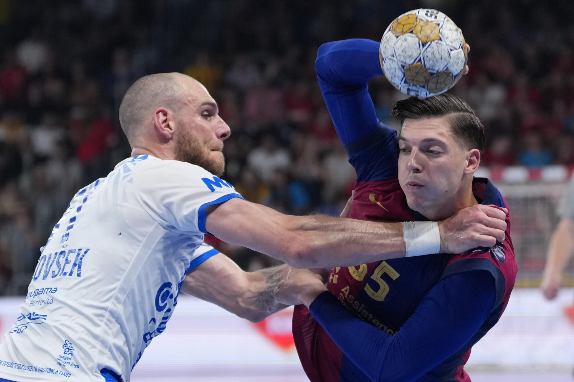 El jugador del FC Barcelona, Makuc (d), intente superar al defensor del OTP Bank Pick Szeged durante el encuentro de vuelta de los play off de la EHF que disputan hoy jueves FC Barcelona y OTP Bank Pick Szeged en el Palau Blaugrana, en Barcelona. EFE / Alejandro García.