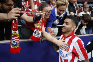 El delantero del Atlético de Madrid Ángel Correa (d) celebra con aficionados tras marcar el cuarto gol del partido de la jornada 37 de LaLiga contra el Betis en el Riyadh Air Metropolitano en Madrid, este domingo. EFE/ Mariscal
