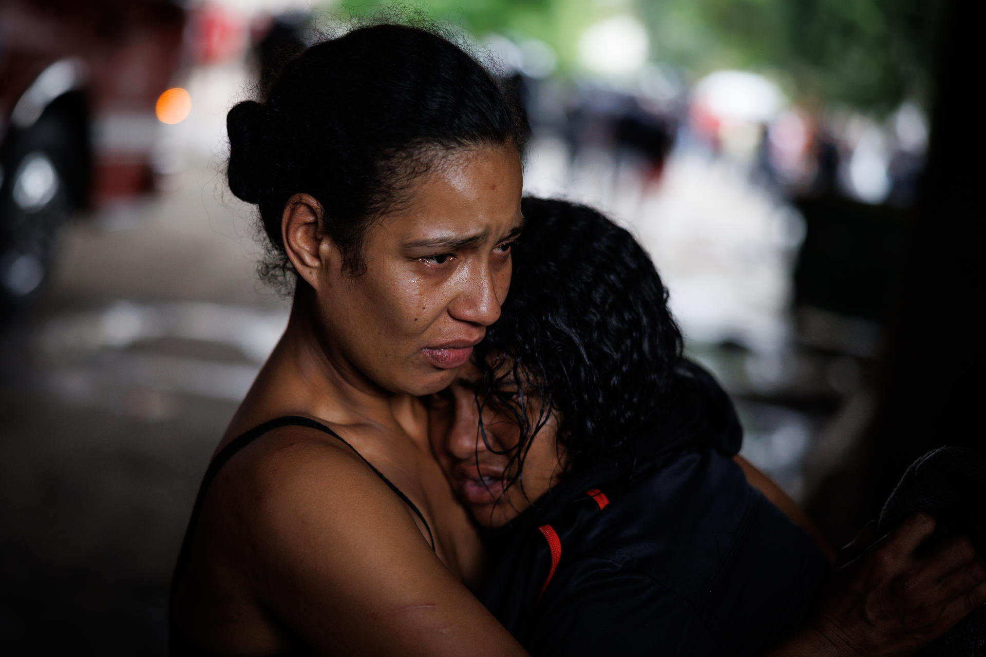 Dos habitantes de la favela Moinho lloran por el efecto de los gases lacrimógenos durante una manifestación contra el accionar de la Policía en una jornada de desalojo este martes, en Sao Paulo (Brasil). EFE/ Isaac Fontana