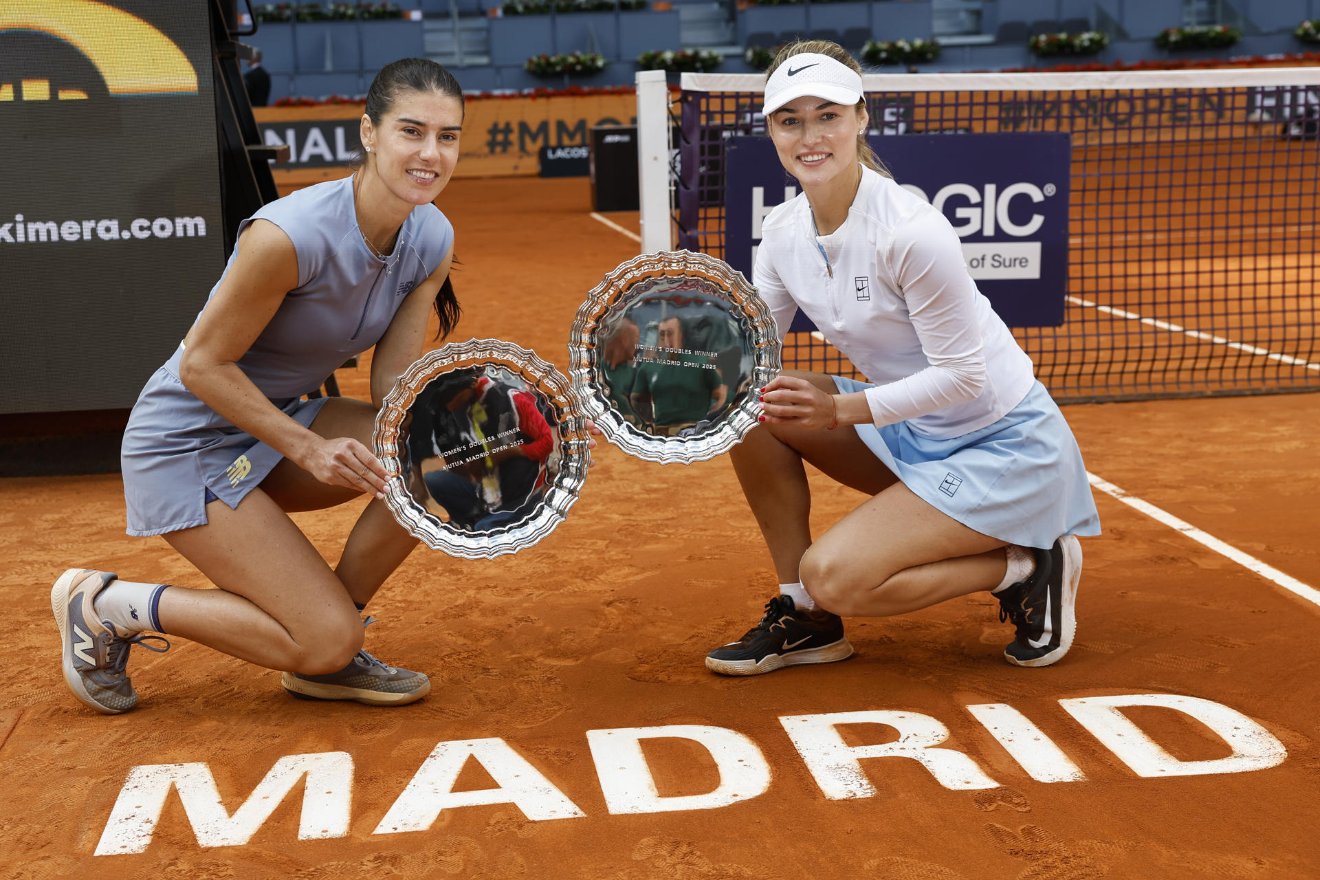 La pareja formada por las tenistas Anna Kalínskaya (d) y Sorana Cîrstea (i) celebra la victoria con el trofeo en la final de dobles femenina del Mutua Madrid Open de tenis disputada ante las tenistas Veronika Kudermétova y Elise Mertens, en la Caja Mágica, en Madrid, este domingo. EFE/ Chema Moya