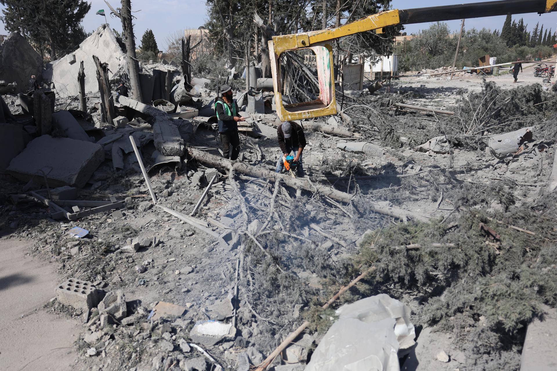 Fotografía del 18 de marzo de 2025 que muestra a trabajadores retirando escombros de un edificio un día después de un ataque aéreo israelí en la ciudad de Deraa, en el sur de Siria. EFE/EPA/MOHAMMED AL RIFAI