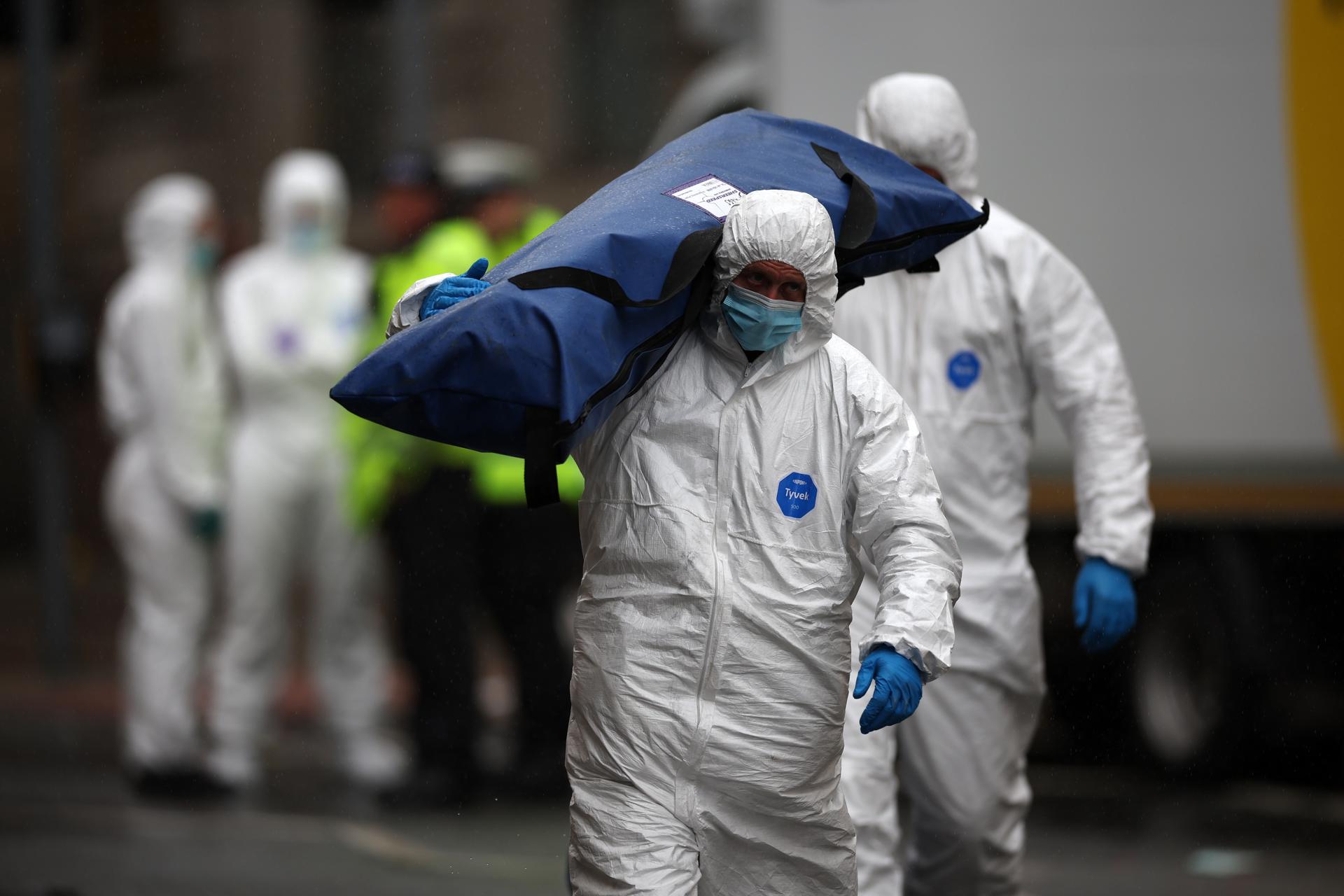 Un forense lleva una tienda encima a la escena del atropello durante la celebración del título en el centro de la ciudad de Lierpool, Gran Bretaña. EFE/EPA/ADAM VAUGHAN