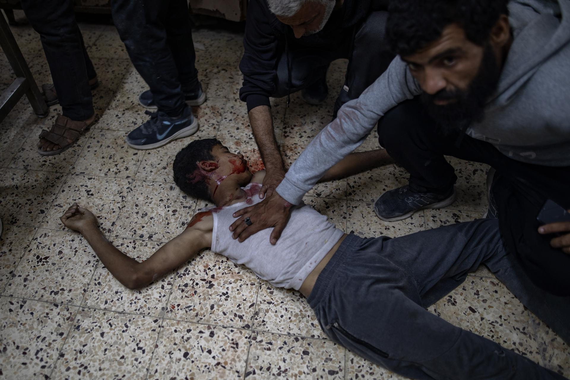 Palestinos se reúnen alrededor del cuerpo de una víctima de un ataque aéreo israelí, en el Hospital Al-Shifa en la ciudad de Gaza, 07 de mayo de 2025. Según la agencia de noticias palestina WAFA, al menos 25 personas murieron en ataques aéreos israelíes en un restaurante y una zona de mercado en el barrio de Al-Rimal de la ciudad de Gaza. EFE/EPA/HAITHAM IMAD -- ATENCIÓN EDITORES: CONTENIDO GRÁFICO --