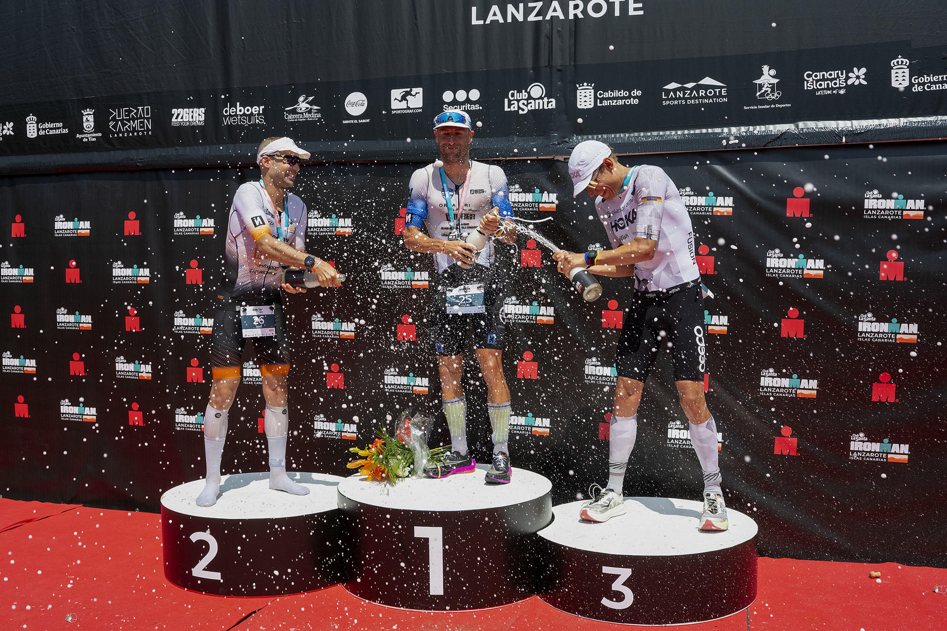 Podio de la prueba masculina del Ironman Lanzarote 2025, triatlón que se disputa hoy sábado por toda la isla. El ganador Dylan Magnien (c); Jordi Montraveta, segundo clasificado (i); y Mathias Lyngso, tercer clasificado (d). EFE/ Adriel Perdomo