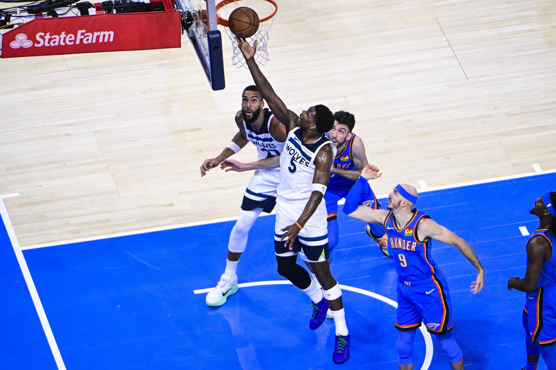 El escolta de los Minnesota Timberwolves Anthony Edwards (c), lanza a canasta durante el quinto juego de las finales del Oeste, cuya serie han ganado por 4-1 Oklahoma City Thunder, primer equipo en las Finales de la NBA. EFE/EPA/GERALD LEONG