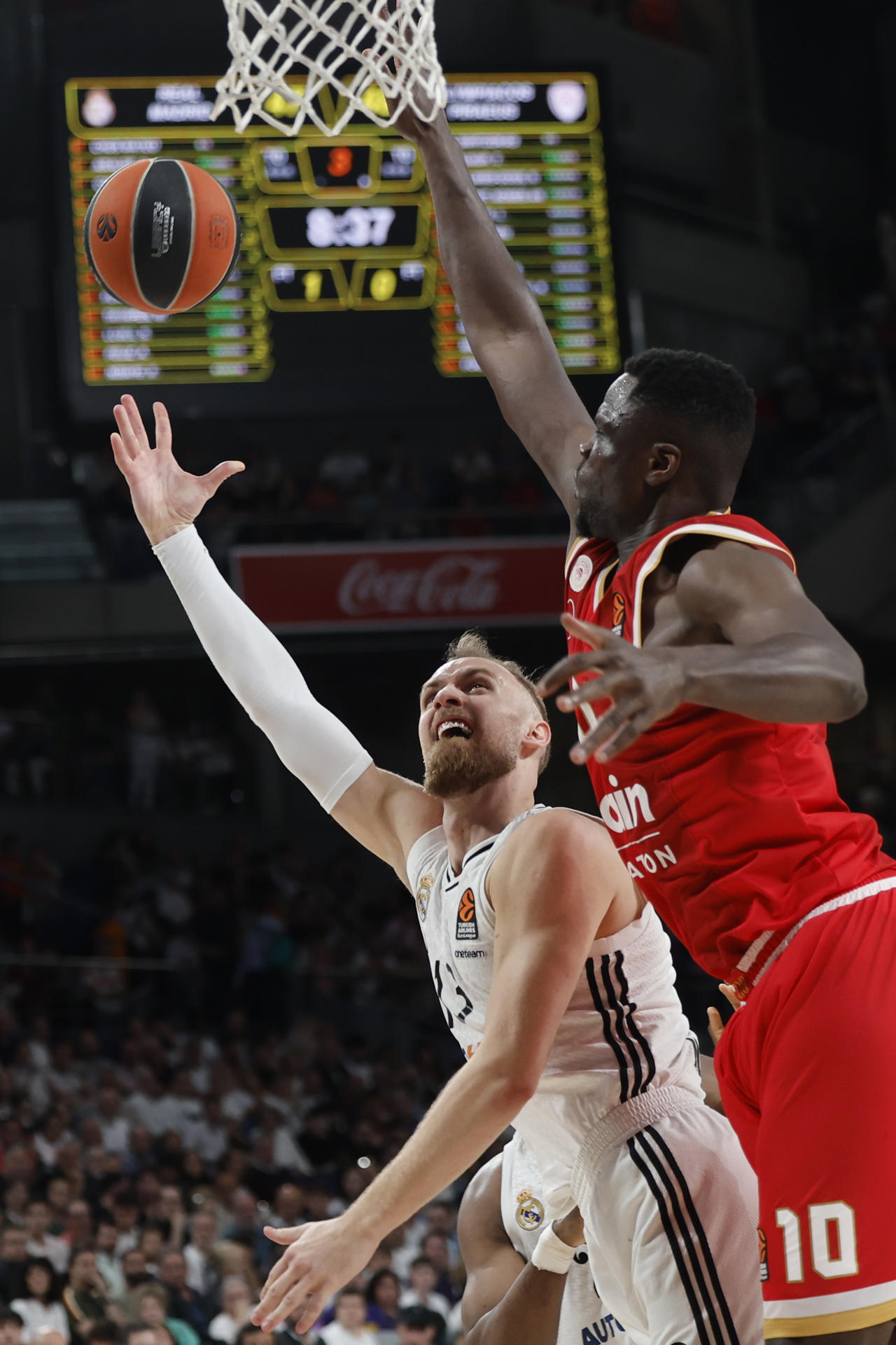 El alero bosnio del Real Madrid, Dzanan Musa (i), lanza a canasta ante el pivot francés de Olympiacos, Moustapa Fall, durante el cuarto encuentro de los play off de la Euroliga que disputan hoy jueves Olympiacos y Real Madrid en el Movistar Arena, en Madrid. EFE / Sergio Perez.